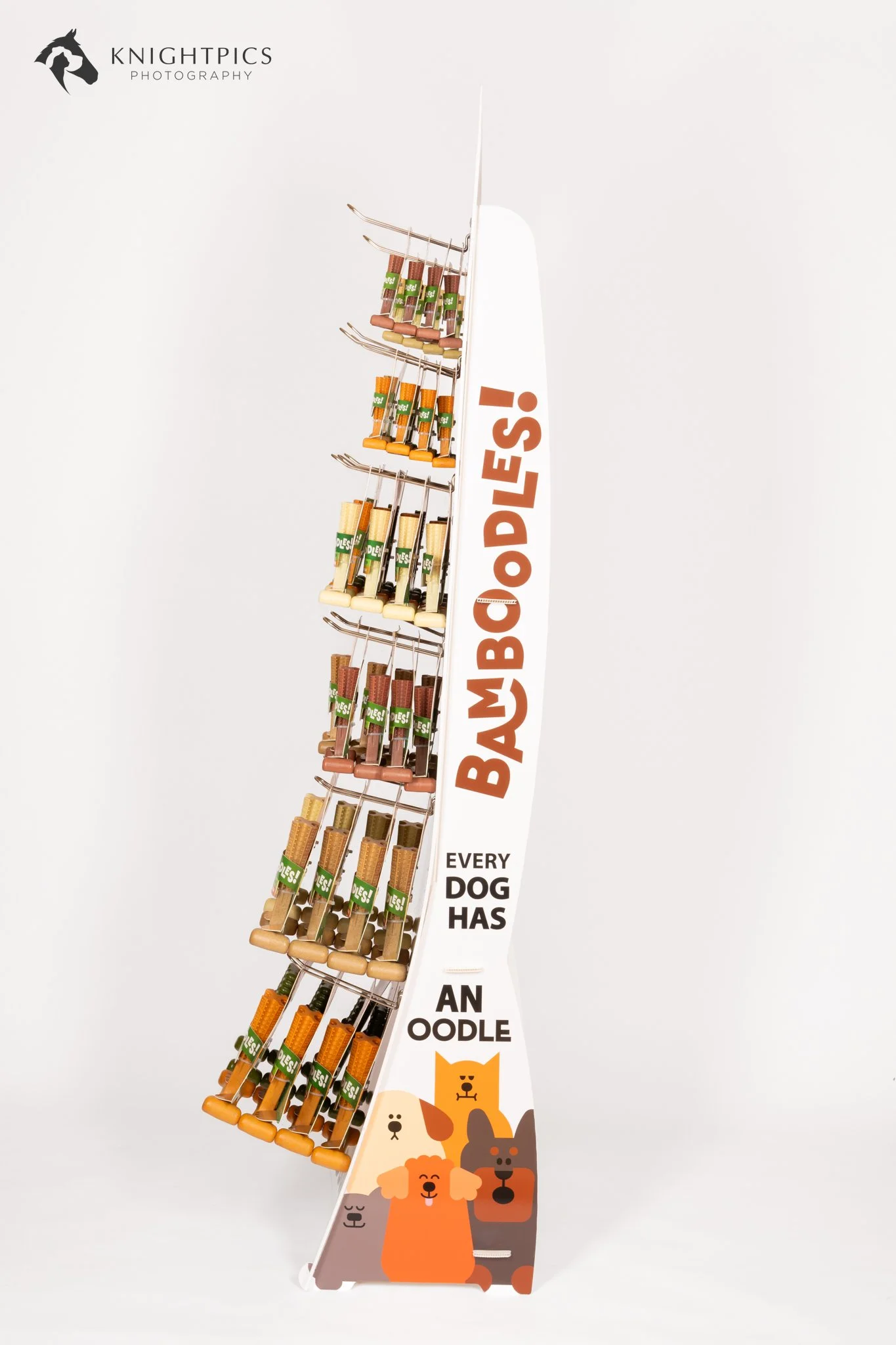 Side-view photography of a Bamboodles branded retail display, highlighting the product arrangement and promotional signage used to present dog chew toys in a retail environment.