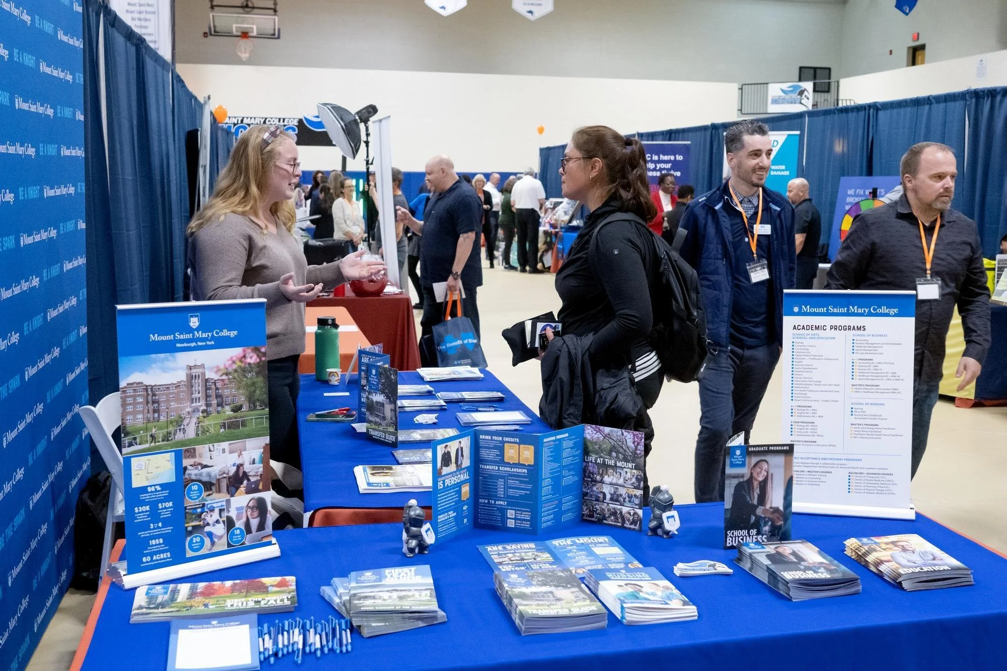  Representatives from the Mount engage with attendees at their booth during the Orange County Business Expo, one of the many local institutions highlighting their community involvement and resources at the annual event.  