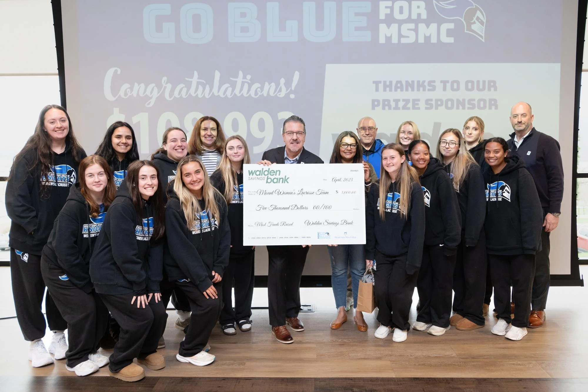 Mount Saint Mary College’s Women’s Lacrosse team raised the most money during the Go Blue campaign, earning nearly $11,500 in gifts. They are seen here with their coaches and Derrik R. Wynkoop (center), Walden Savings Bank President and CEO, receiv