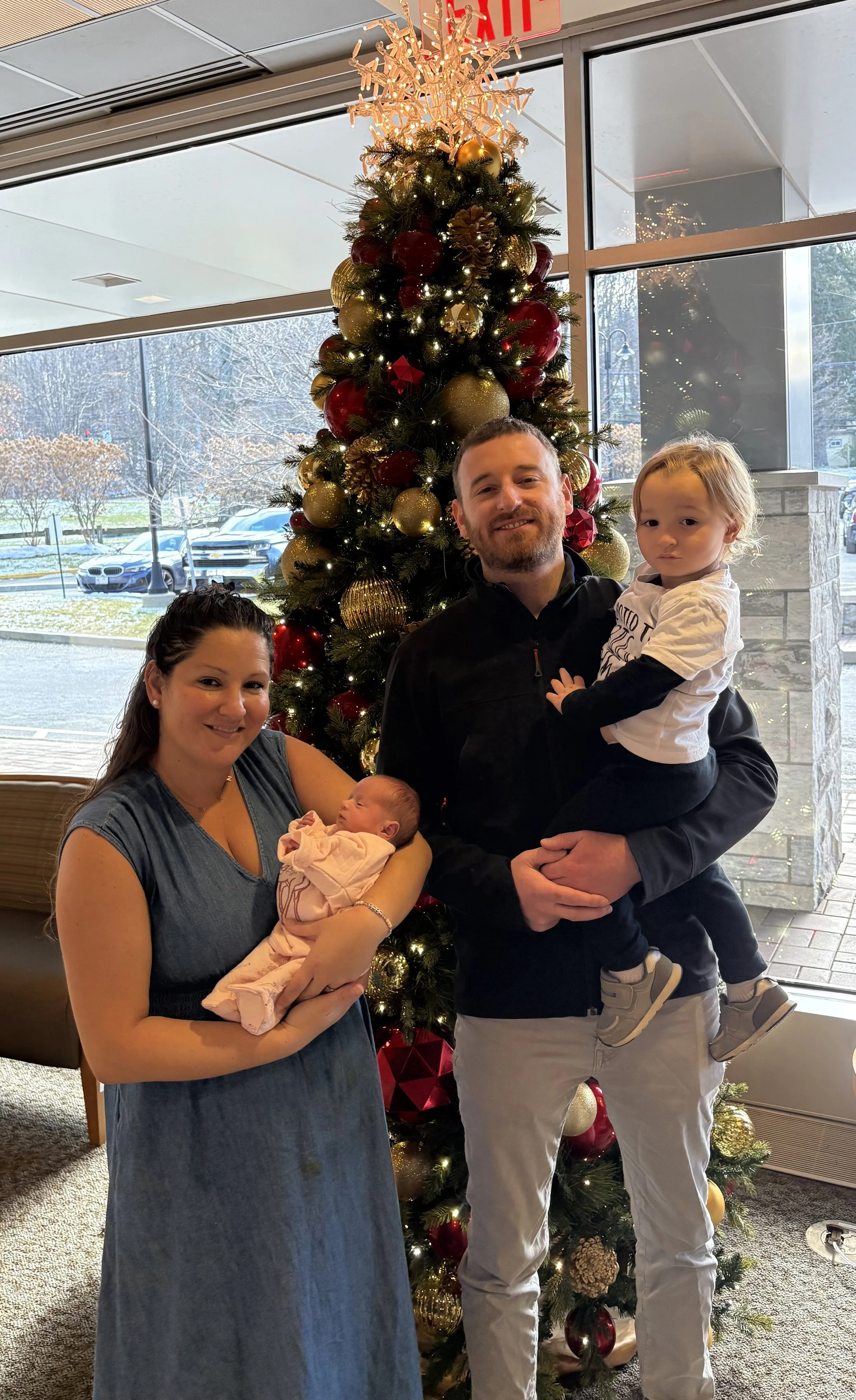 Family photo in front of a Christmas tree.