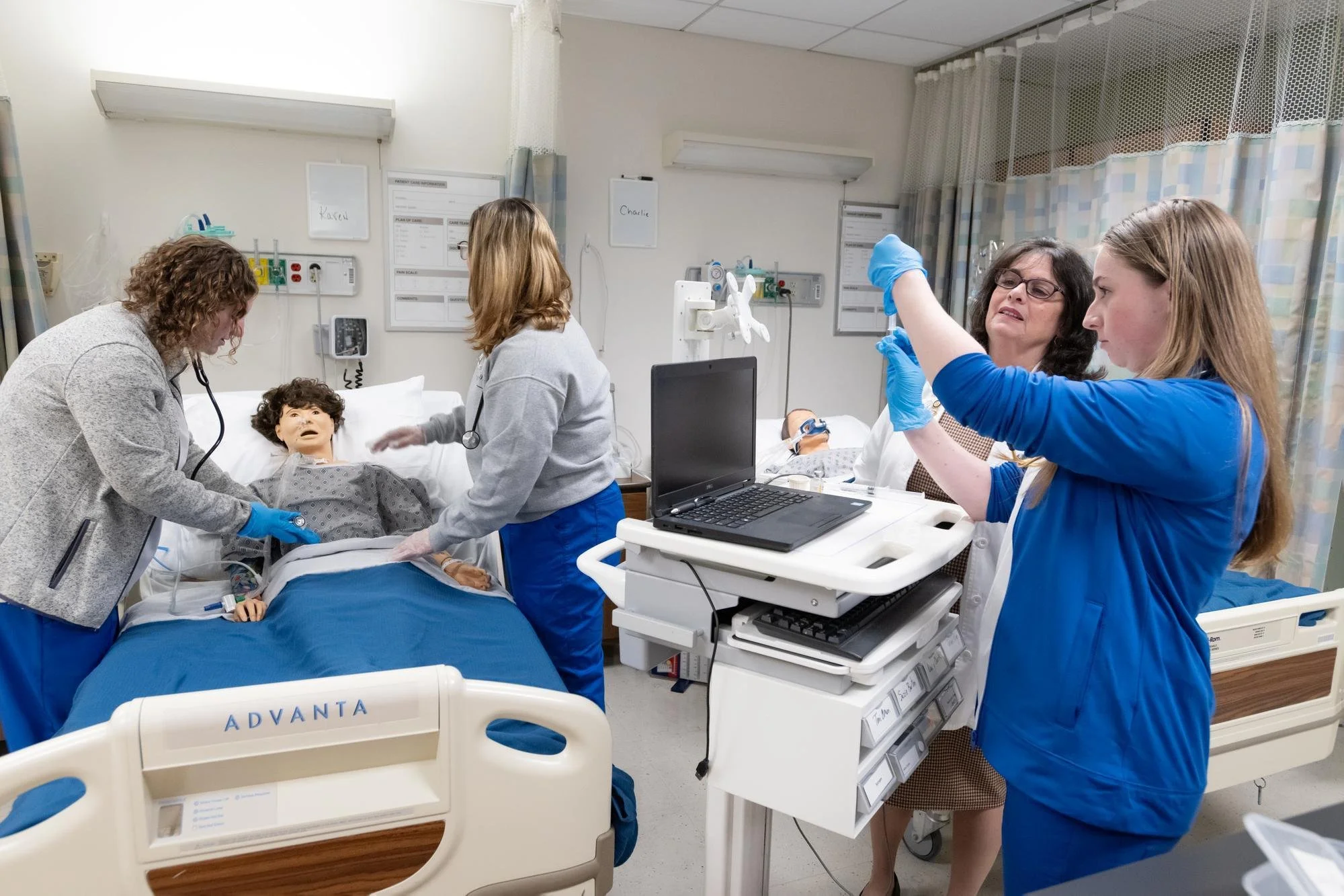 Three Mount Nursing students and faculty member in the Nursing Simulation Lab.