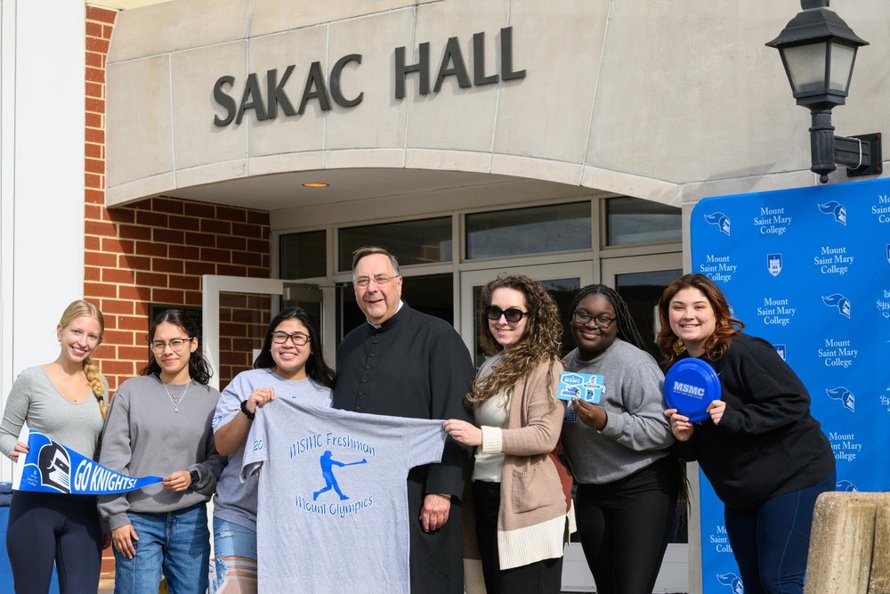   The college celebrated the 20th birthday of freshman residence building Sakac Hall in October. Seen here, a group of students stand with Fr. Gregoire Fluet, Interim President of the college, during the festivities.  