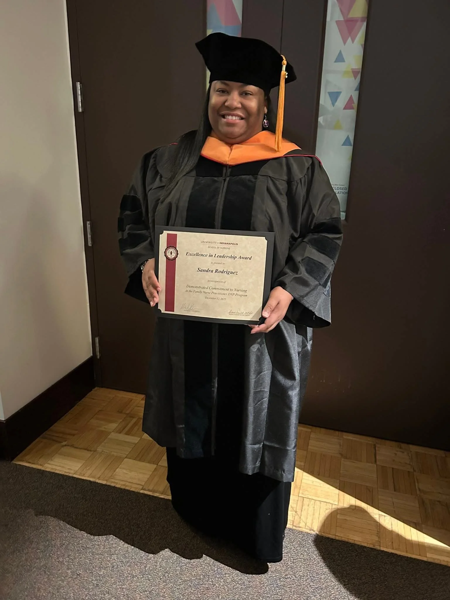 Graduation photo with graduate holding their diploma.