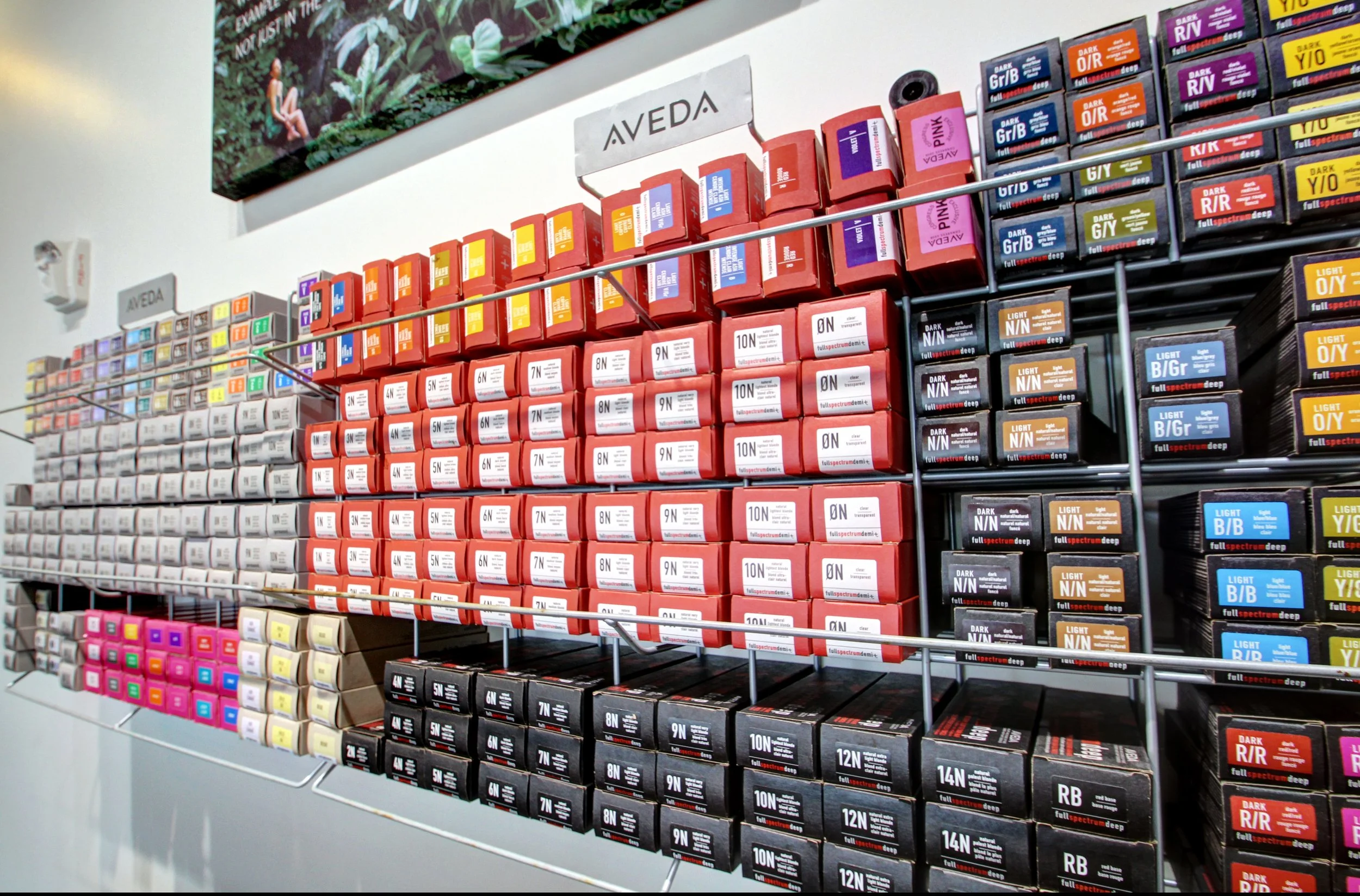 Shelf with organized boxes of hair dye in various colors and shades.