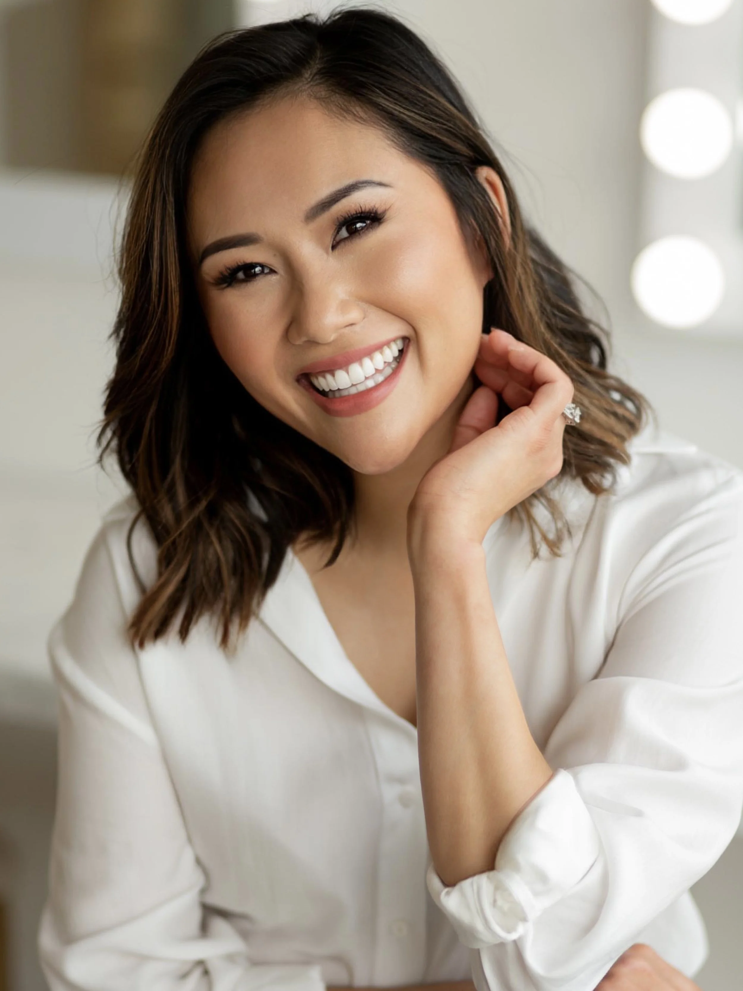 Smiling woman in white shirt sitting indoors