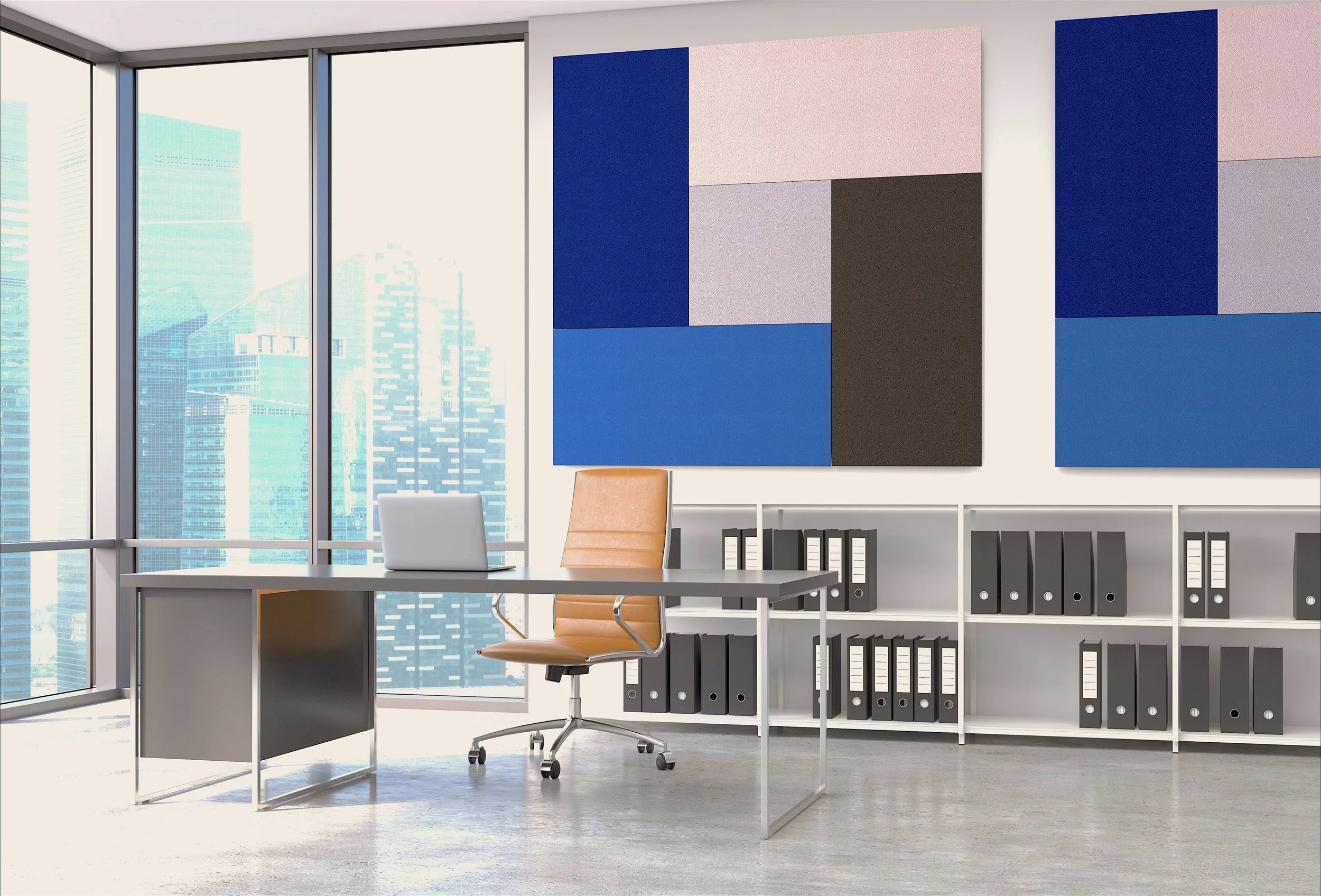 Modern office space with large windows showing city skyscrapers, a desk with a laptop, a tan office chair, and wall art with geometric shapes in blue, pink, black, and gray. Black file binders are on white shelves behind the desk.