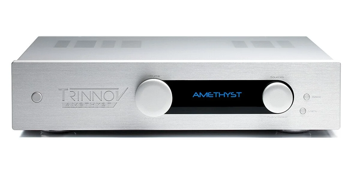 Silver Trinnov Amethyst audio amplifier with black display showing blue text, large volume knob on the left, smaller source button on the right, and a clean, modern design.
