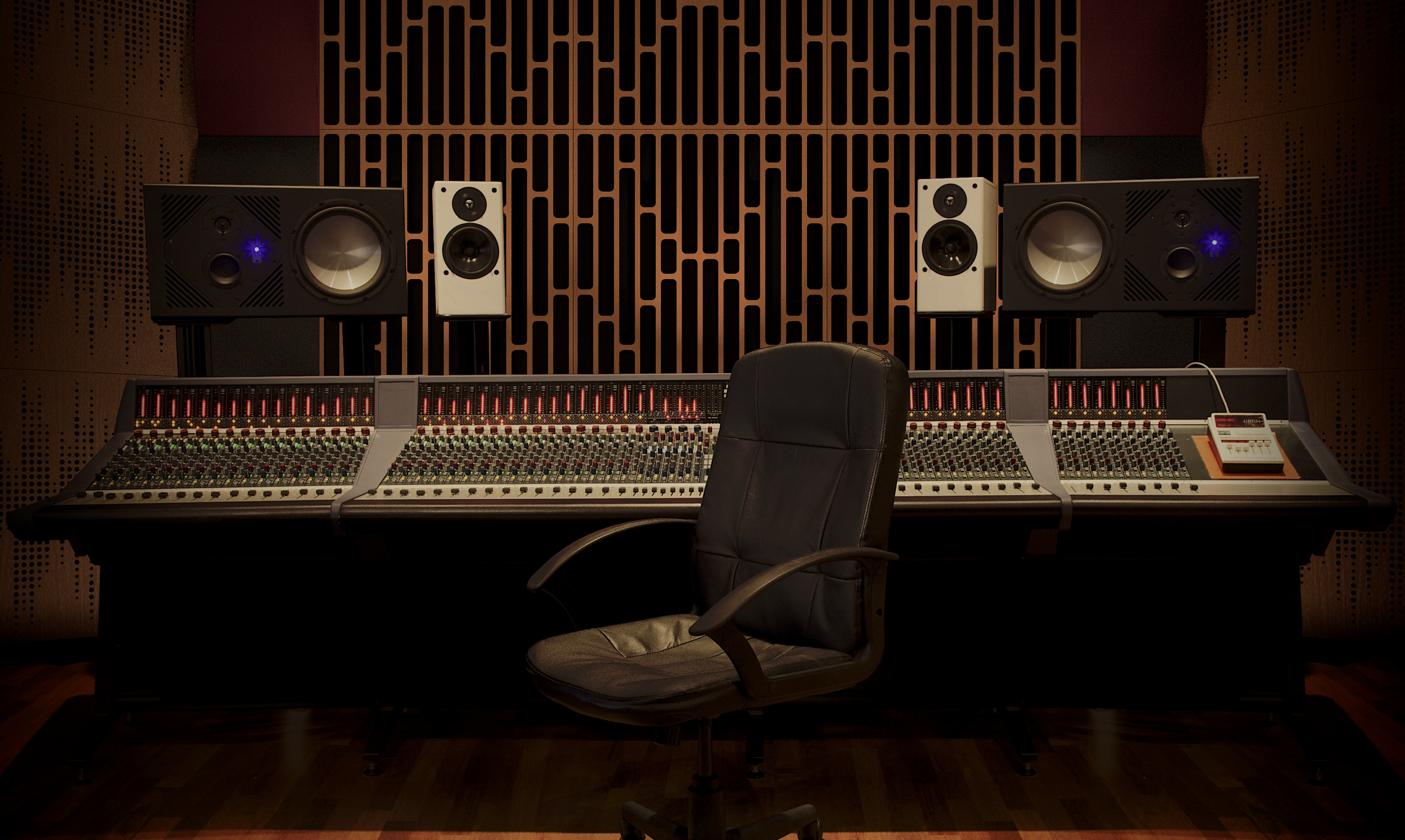 Recording studio with mixing console, studio monitors, a black swivel chair, wooden soundproofing panels, and a keyboard.