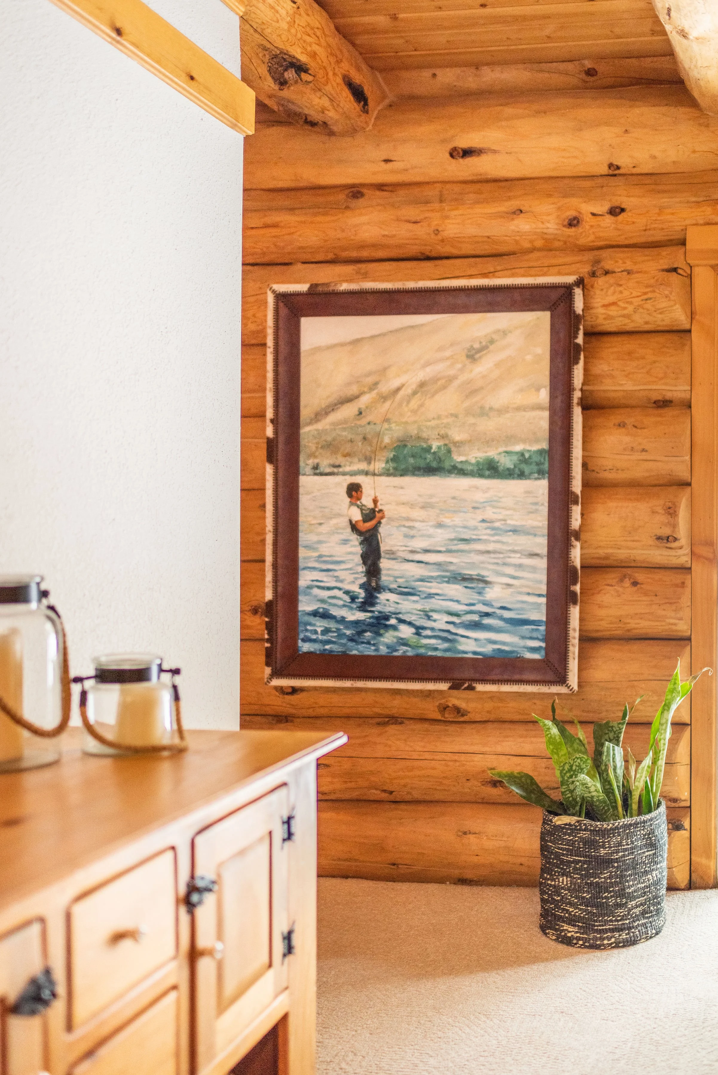 The cabin dining room features a custom fisherman painting of the owner's late father. The artist was found on Etsy and it looks nearly identical to the photograph! We decided to frame in a beautiful cowhide to fit the style of the town.