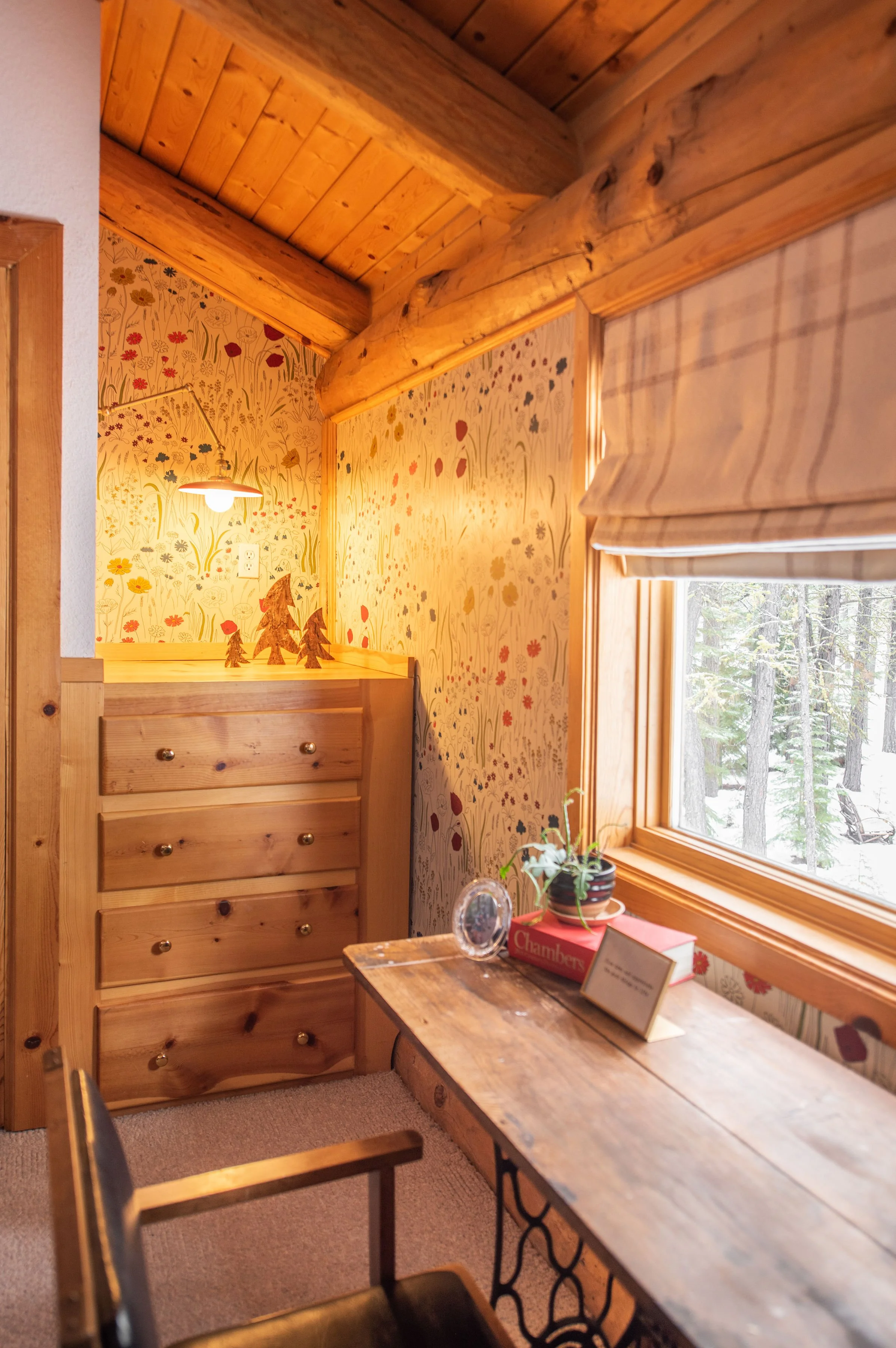 In the kids' bunkroom we featured this beautiful wallpaper by Hygge & West with a red metal swing arm light fixture from Schoolhouse. The vintage sewing table acts as a desk for those who must work while on vacation. The desk chair was found at a loc