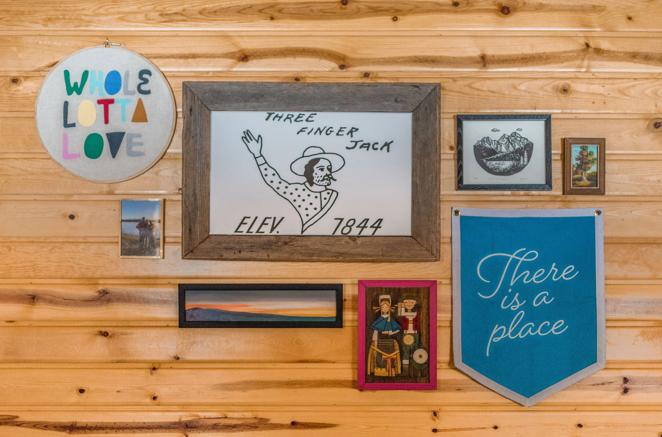 The guest room gallery wall features local art from Lark Modern and Bedouin, a custom felt flag, family photos and vintage finds.