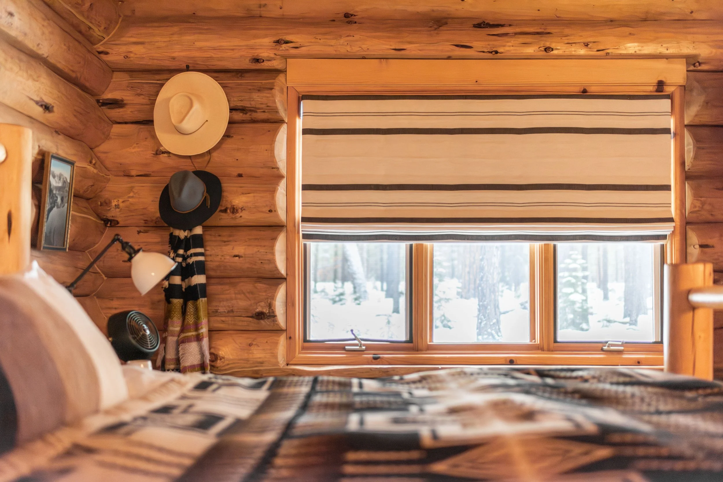 In the primary cabin bedroom, we embraced the western decor and made use of the space with all of the owner's hats. We kept the palette neutral (creams, browns and blacks) and popped with hints of red.