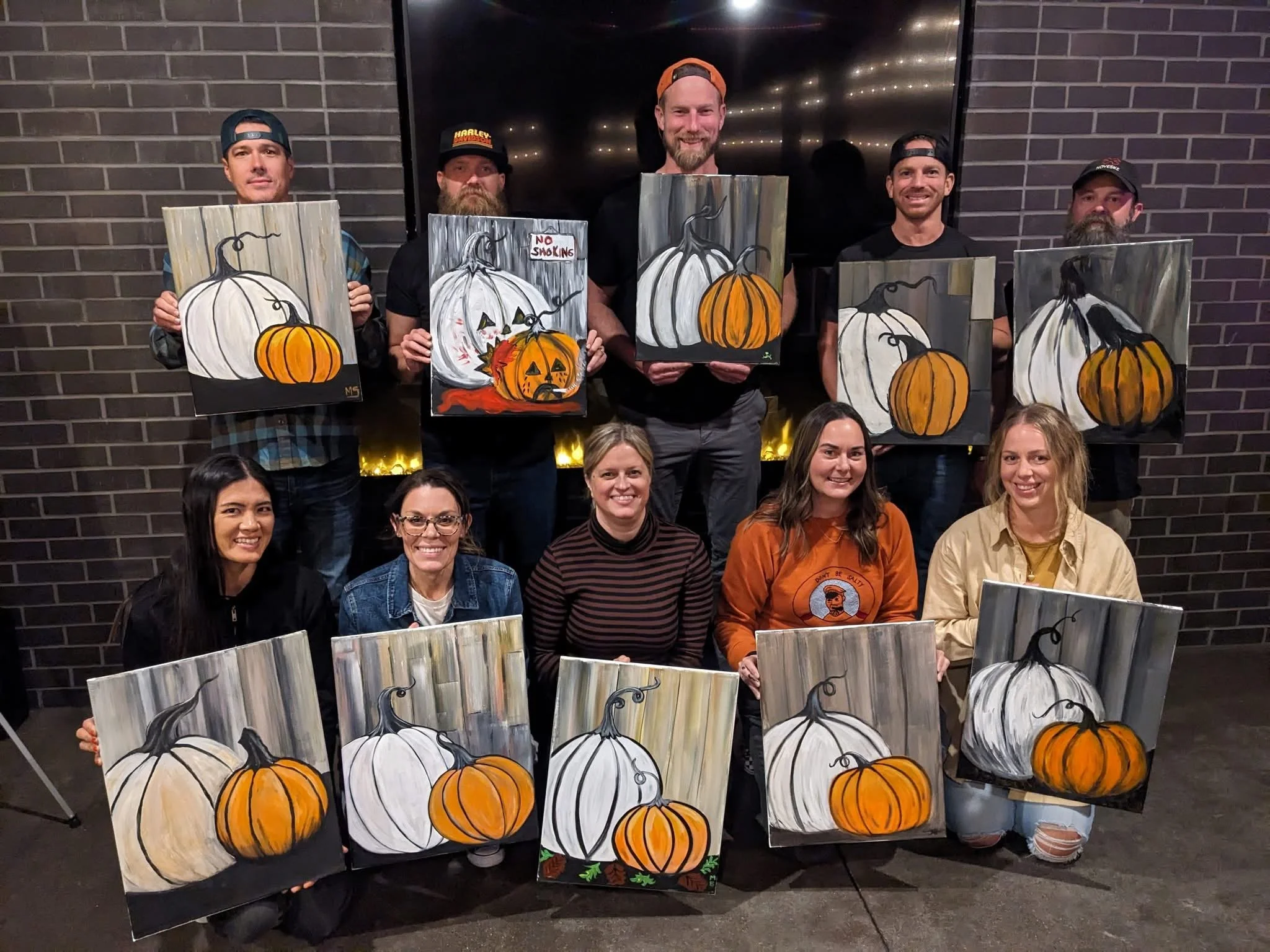 Adult painting party holding finished pumpkin paintings taught by Paint Away Art Studio in Grants Pass