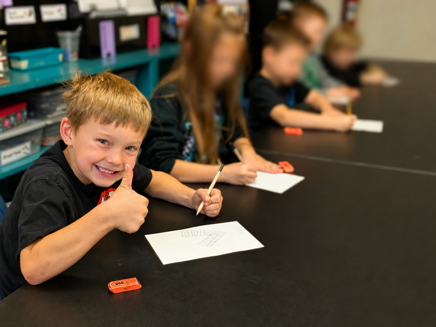 Young art student giving a thumbs-up during a children’s drawing class at Paint Away Art Studio in Grants Pass