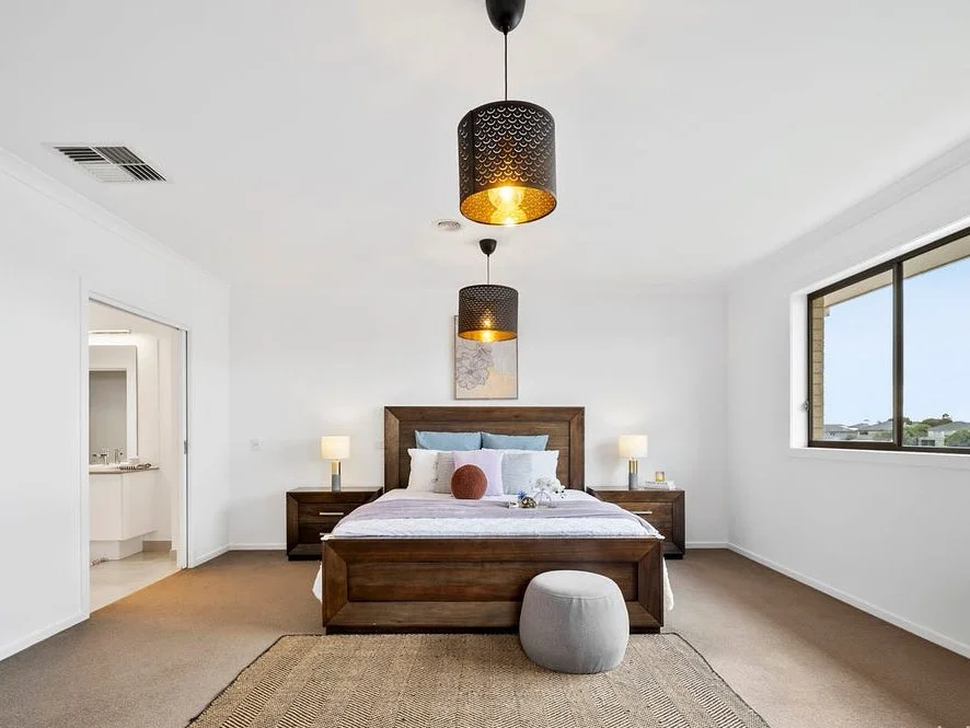 Modern home office with sleek desk, laptop, and chairs. Features a horse artwork, potted plant, and cowhide rug on wooden flooring.