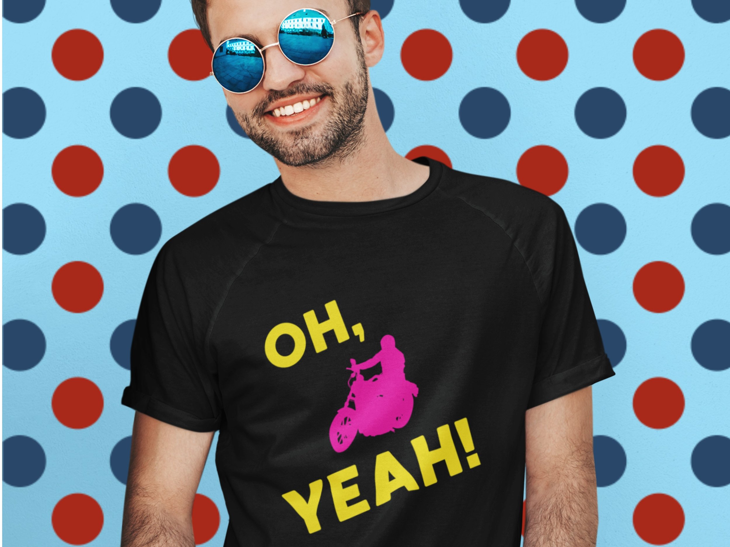 A man wearing a black t-shirt featuring a pink motorcycle and the words, 'Oh Yeah!' in yellow text