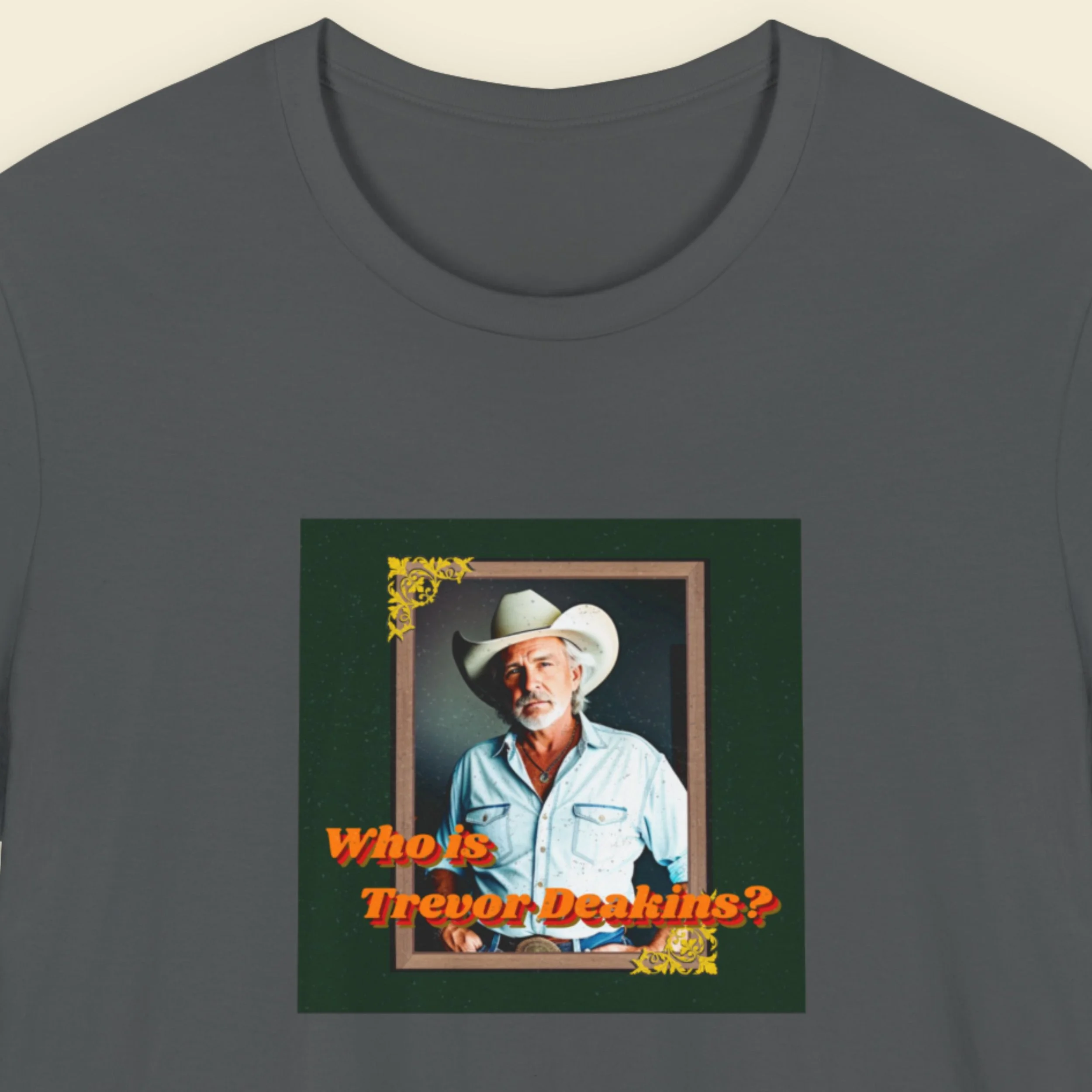 T-shirt with a graphic of a man in a cowboy hat and text 'Who is Trevor Deakins?' on a dark gray background.