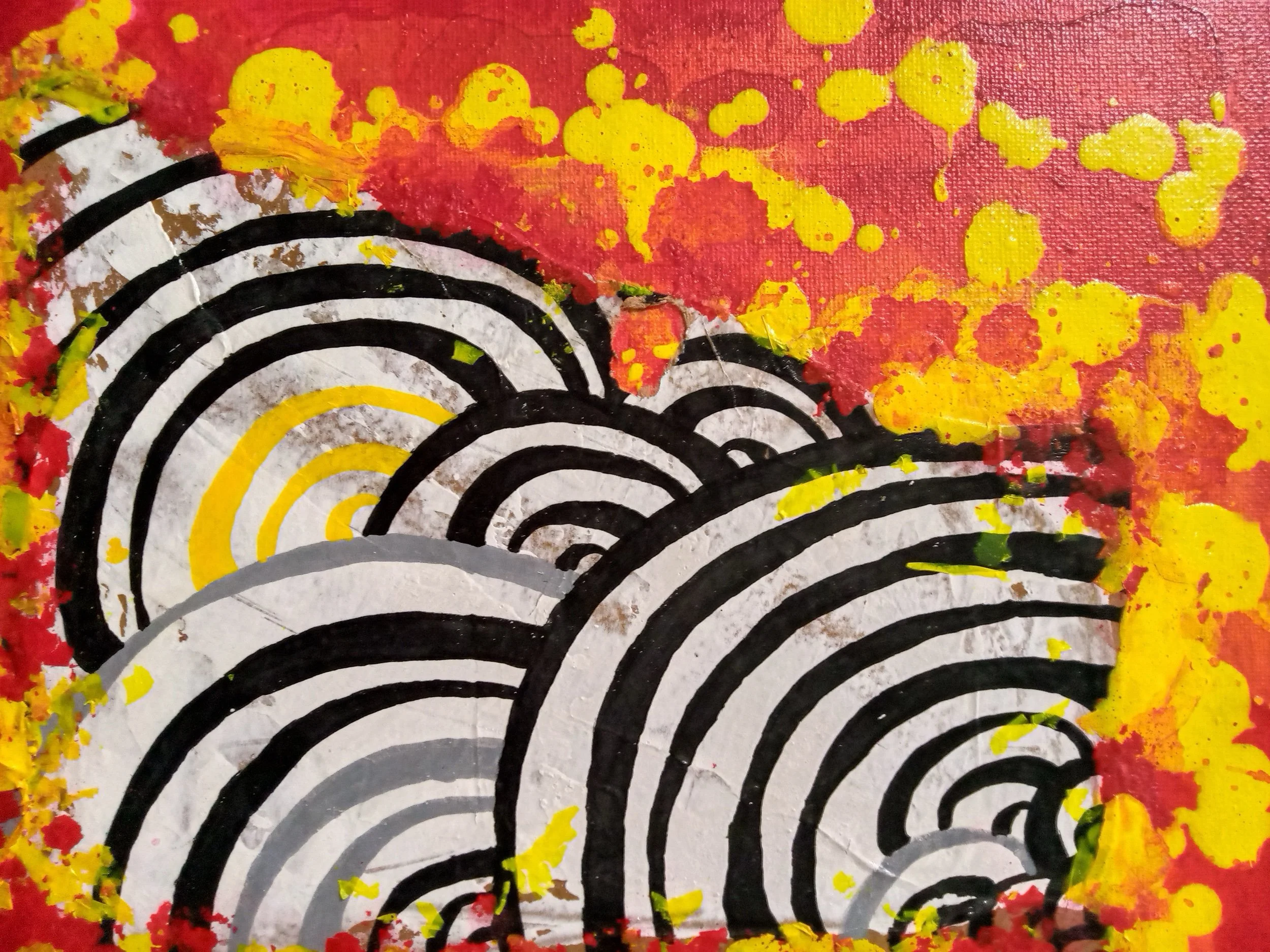 Abstract art with overlapping black and yellow concentric half-circle patterns on a background of red and yellow paint splatters.