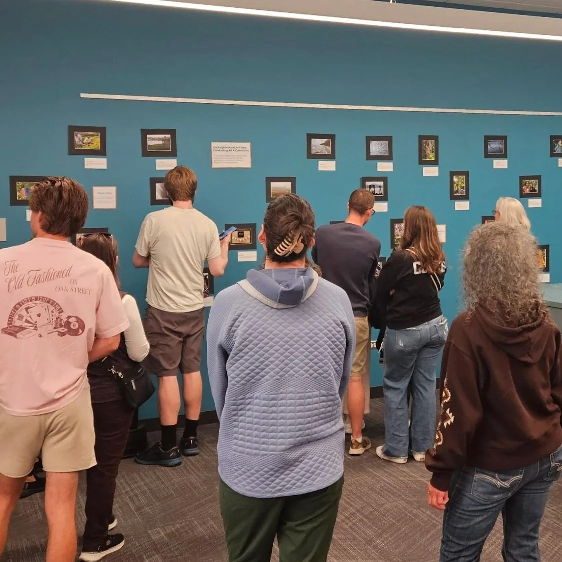 group looking a photography showcase created at palatine library by the community