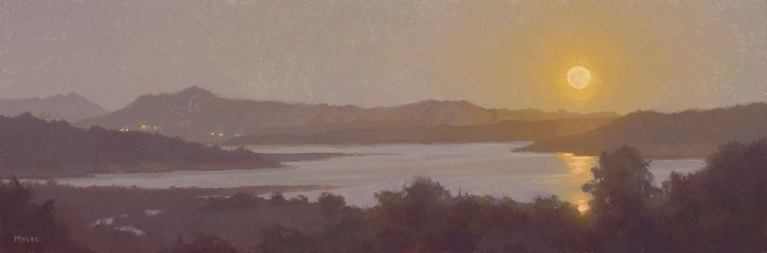 Water and mountains landscape at sunset, with a full moon in the sky.