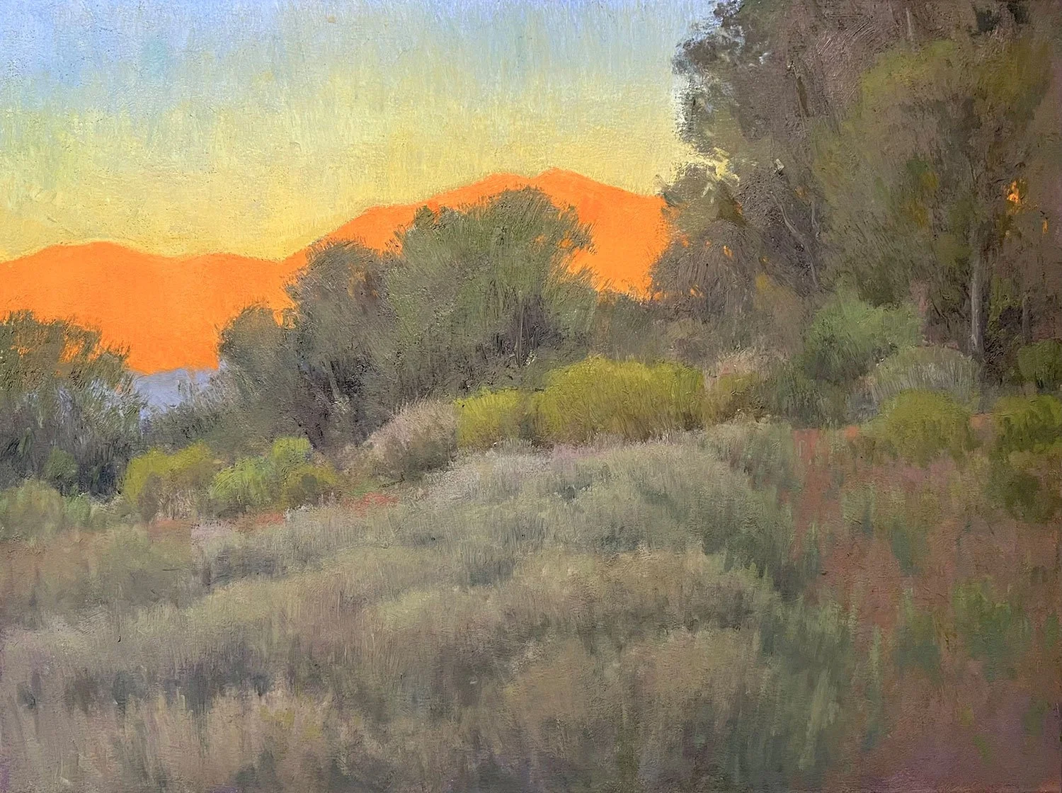 A landscape painting of rolling hills and trees at sunset, with warm orange and yellow tones in the sky and darker greens and browns in the trees and grass.
