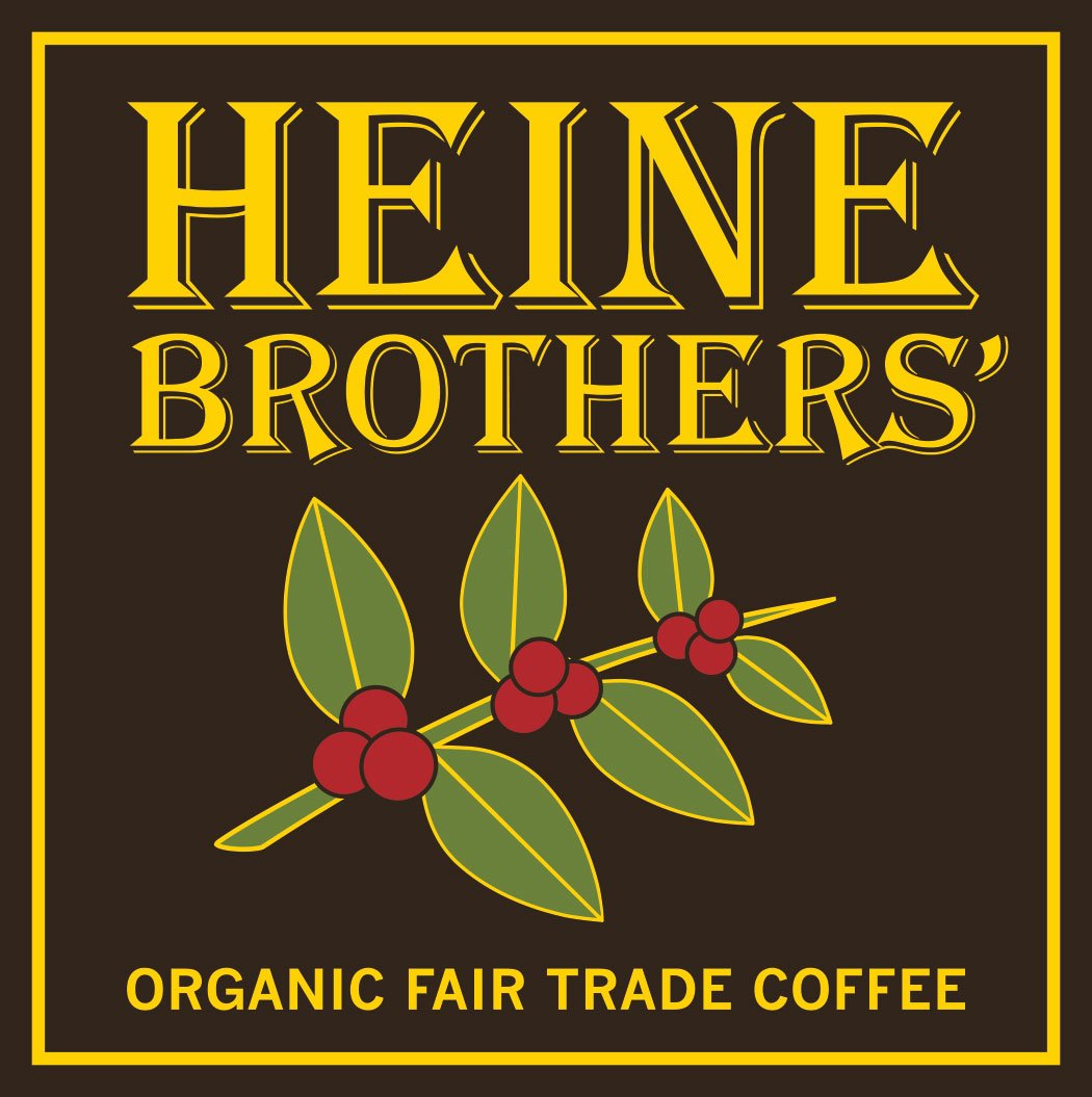 Packaging label for Heine Brothers' organic fair trade coffee featuring a black background, yellow text, and an illustration of a coffee plant branch with green leaves and red berries.