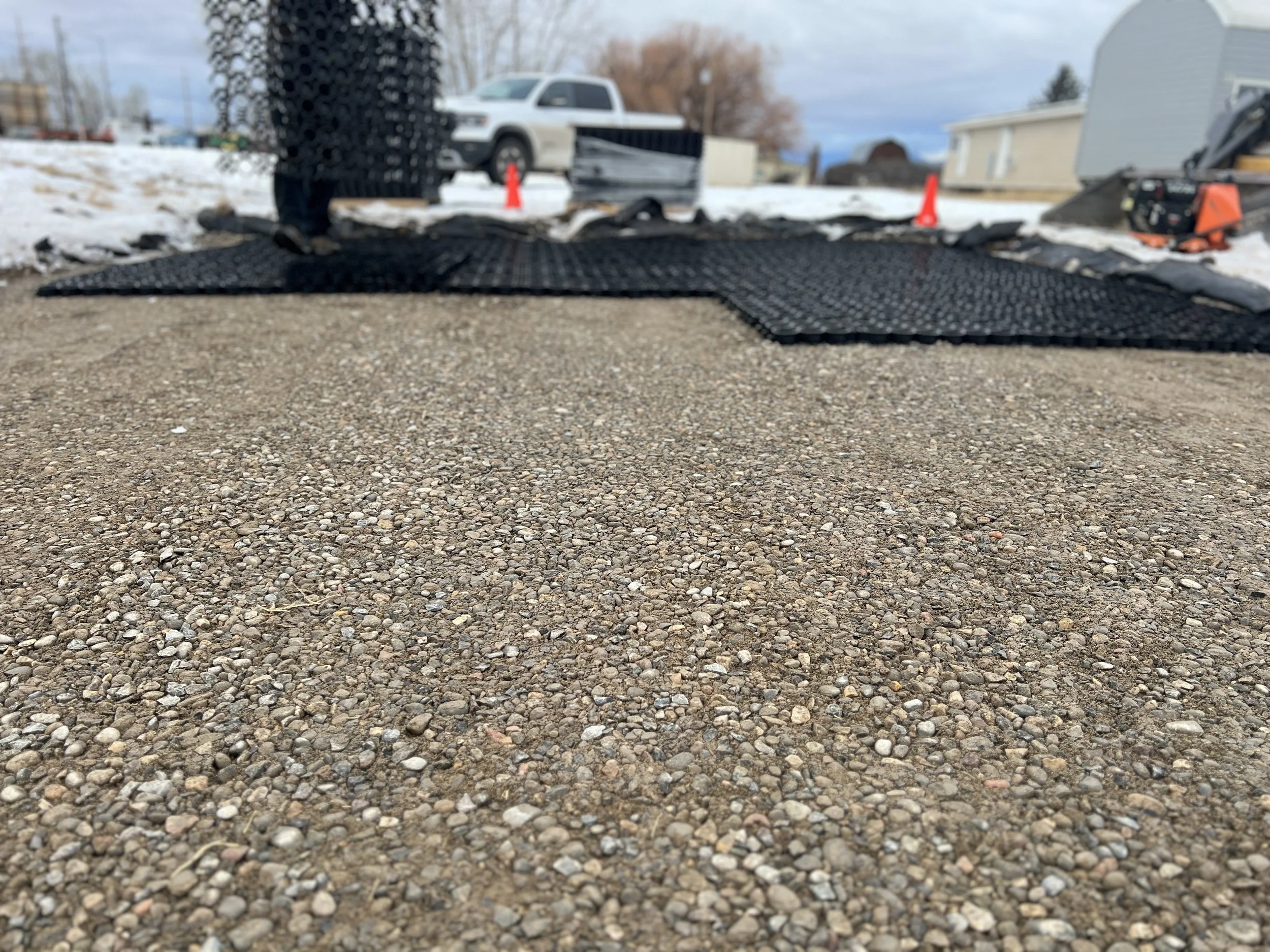 After adding approximately 50 tons of road base aggregate for the base prep (8" height, compacted in 4" flights), TrueGrid panels were snapped together across the base layer surface