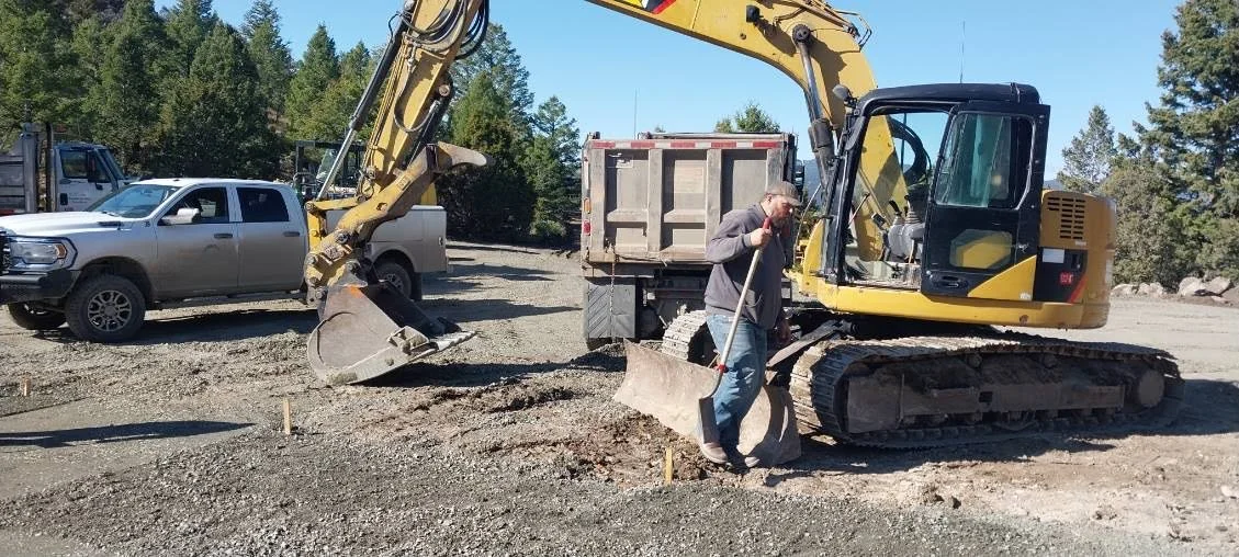 The parking area was excavated to include depth for 8" base gravel and 2" TrueGrid height; non-woven fabric was secured to the leveled native ground
