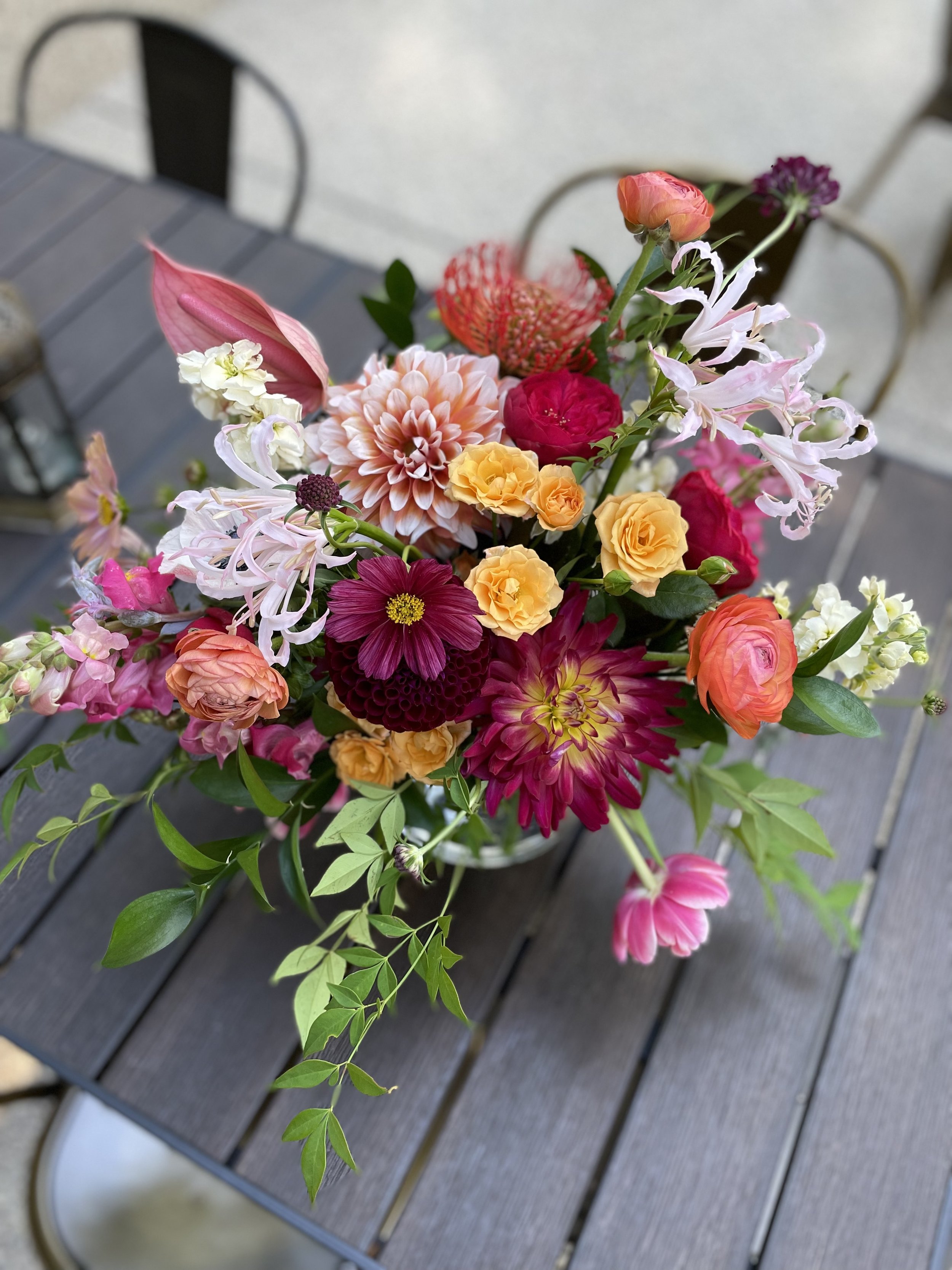 Laurie’s customers, Mariana and Carmen holding hands on a green lawn on their wedding day.