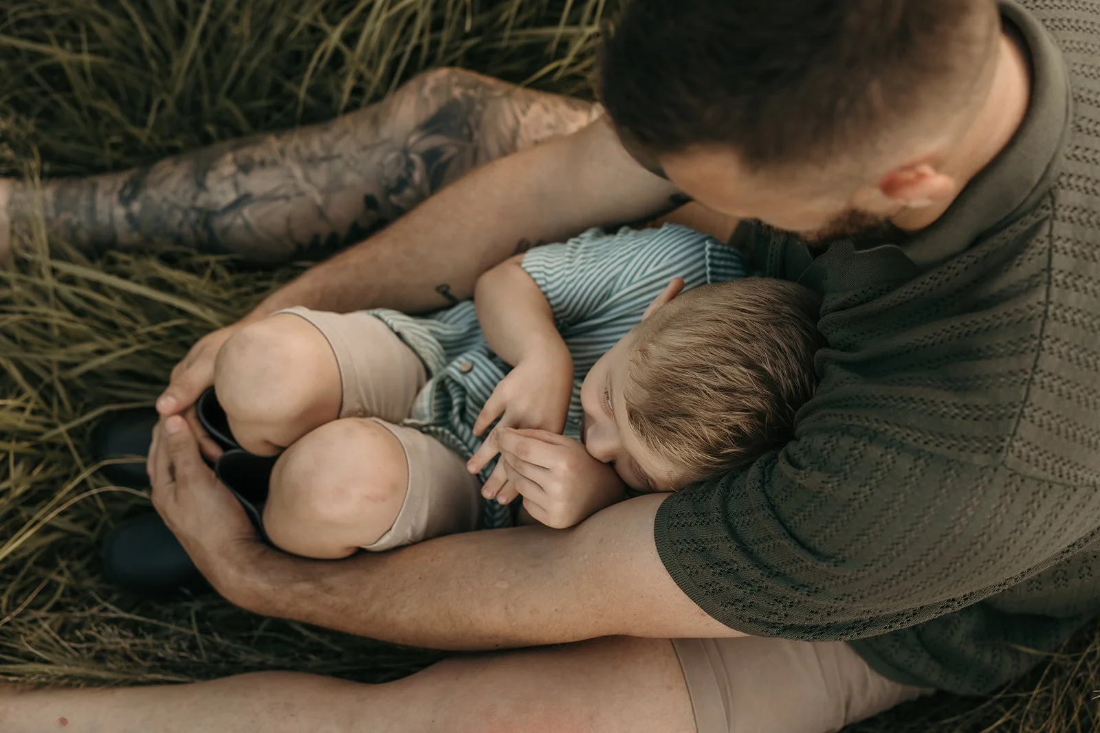 Mackay family photography session of father and son sitting together and cuddling.