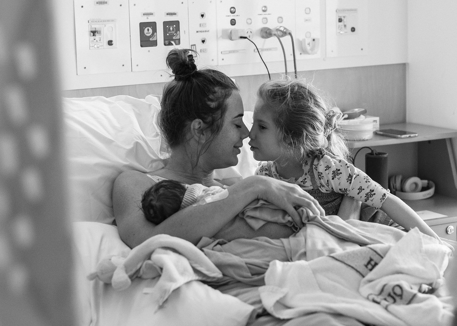 birth photographer in Mackay captures mother together with new baby and older daughter