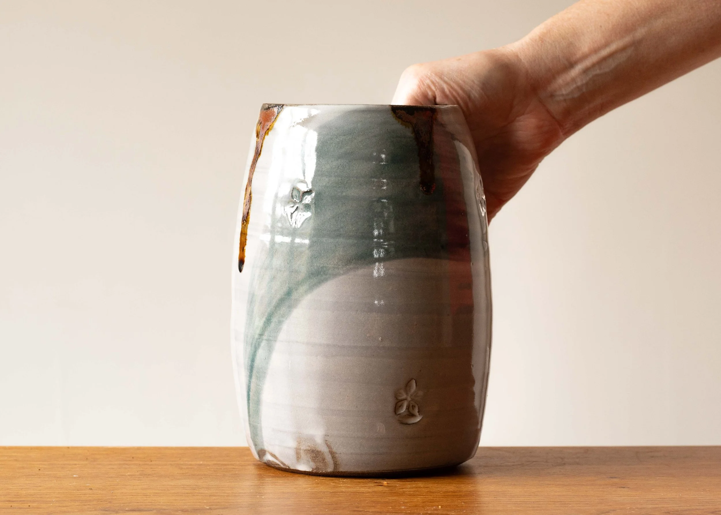 Handmade Pottery Open Vase with Green Brush Marks, with hand for scale.jpg