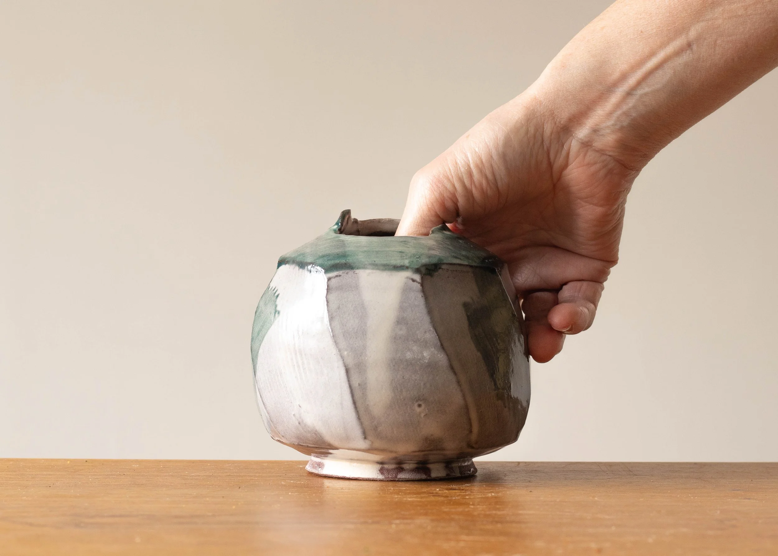 Faceted Enclosed Bowl with Turquoise Decoration, with Hand for Scale.jpg