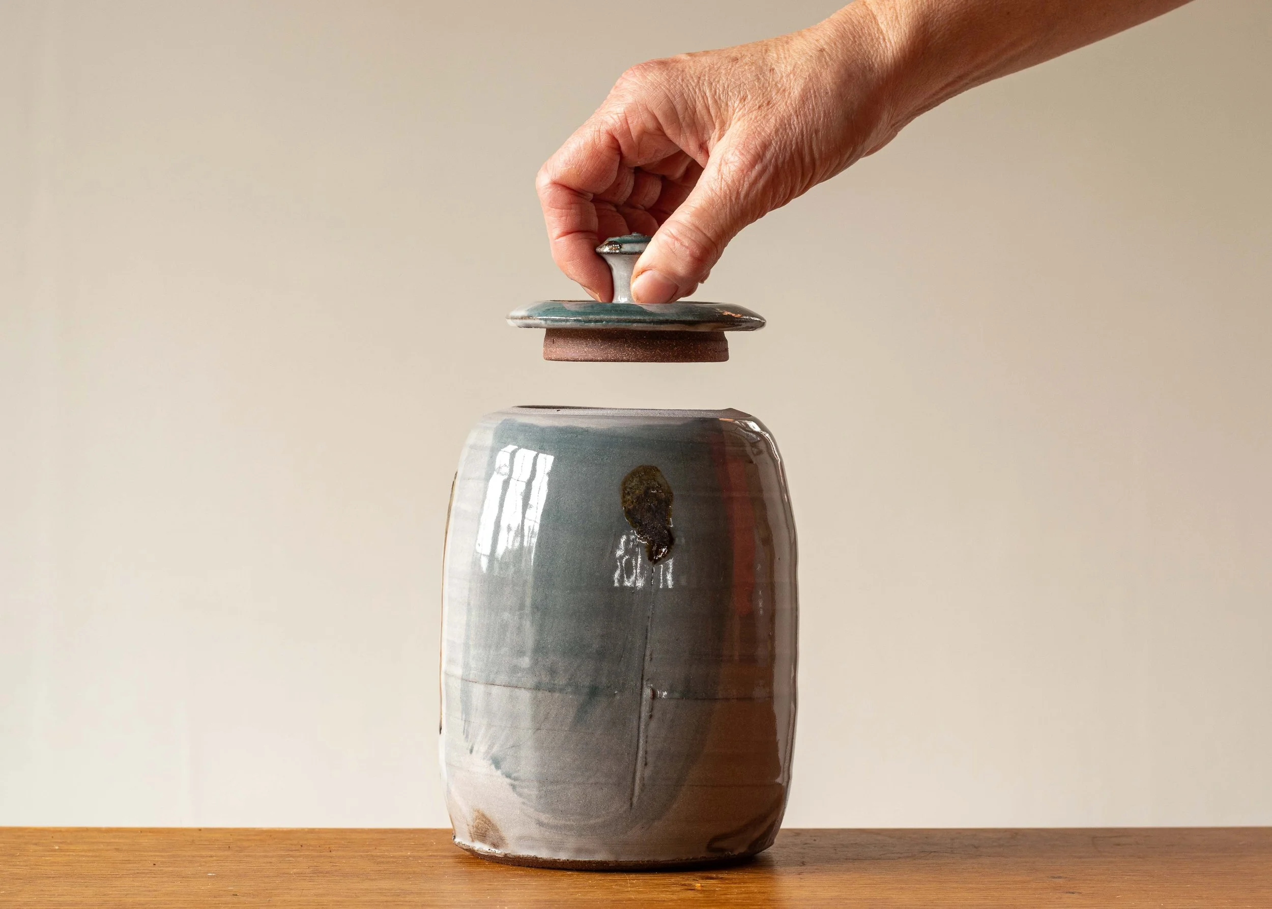Handmade Pottery Lidded Pot with Green Brush Marks #1, with hand for scale.jpg