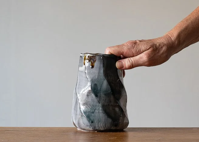 Faceted vase with turquoise brush marks, with hand for scale.jpg