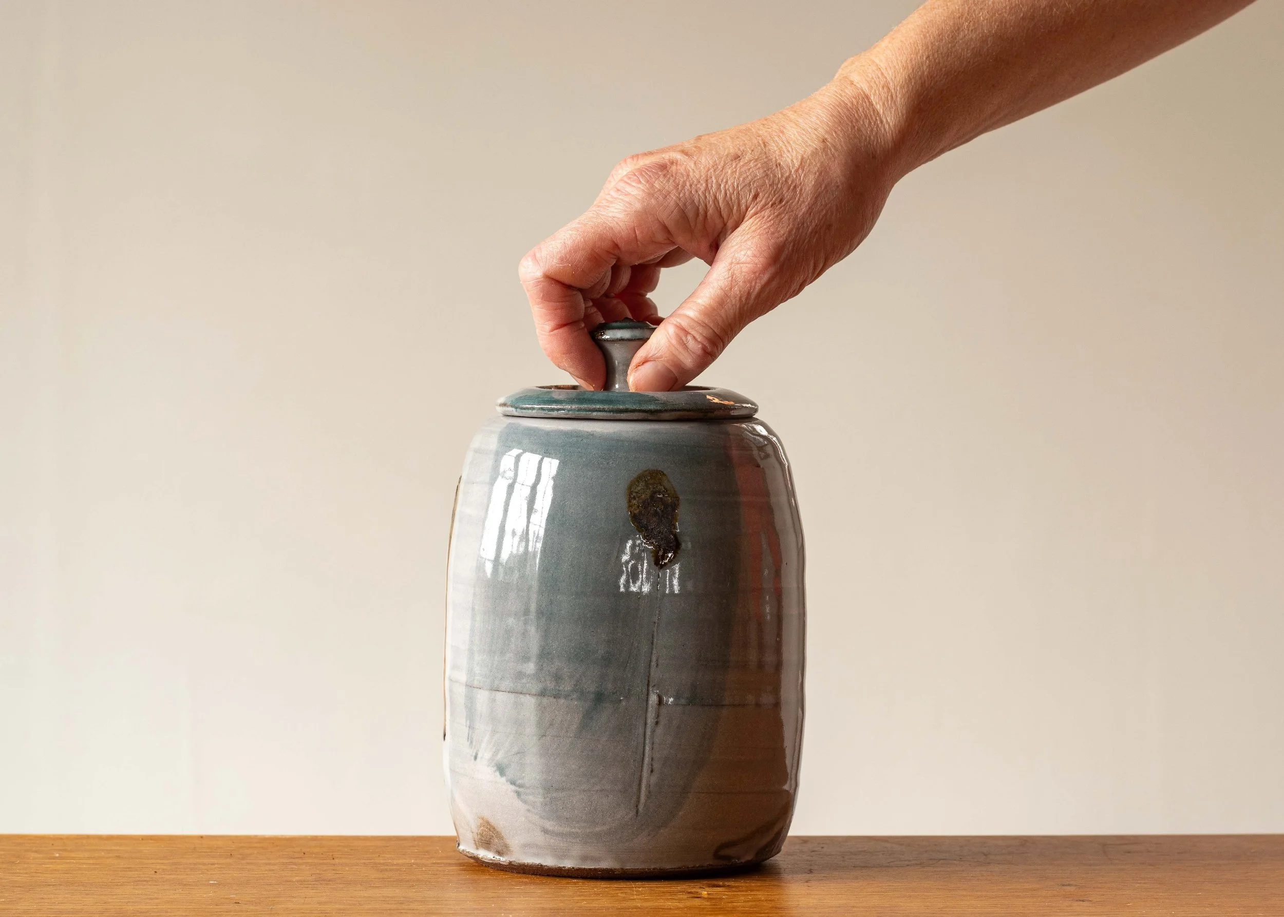 Handmade Pottery Lidded Pot with Green Brush Marks #1, holding lid for scale.jpg