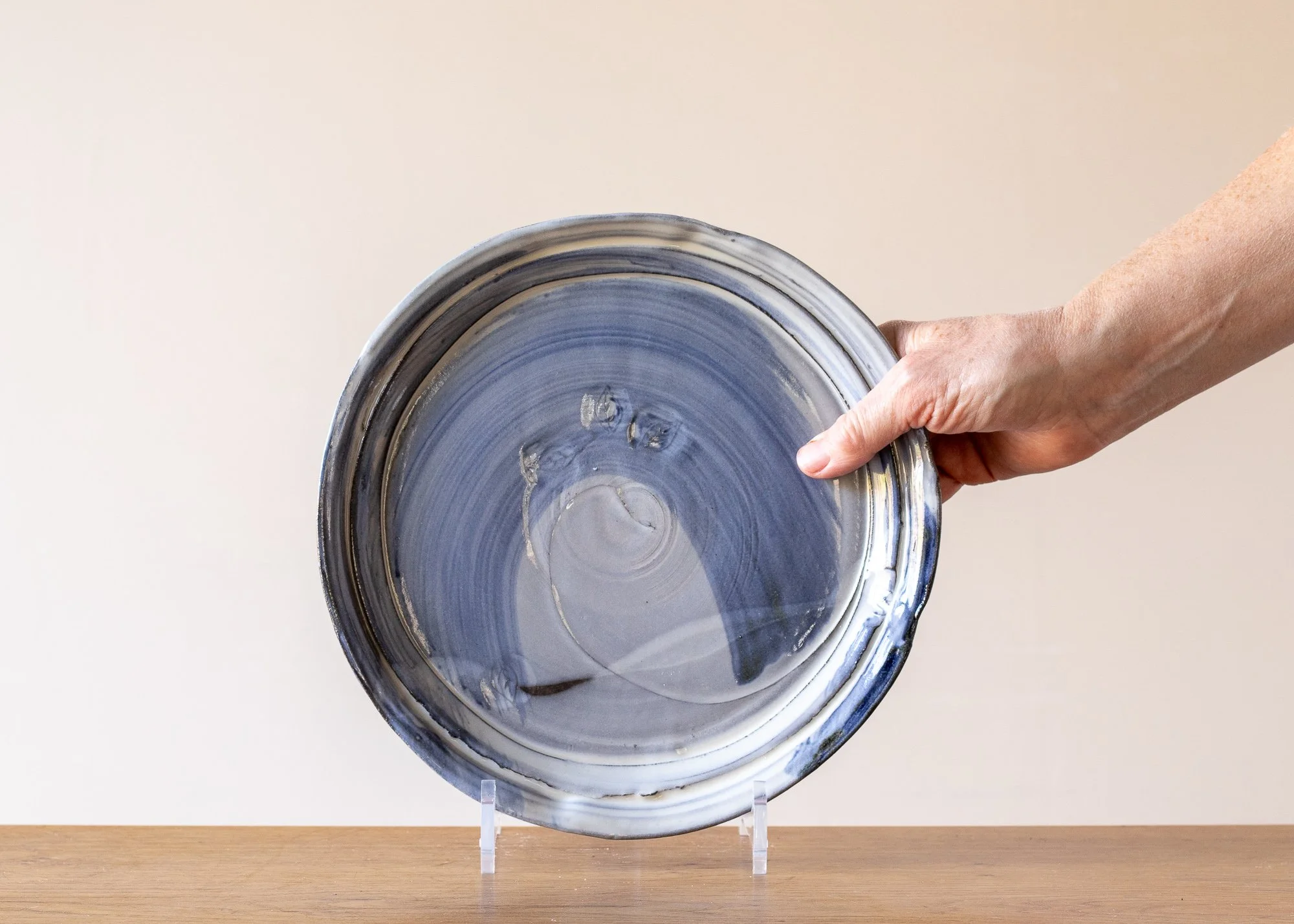 Handmade Pottery Dinner Plate with Pale Blue Brushed Decoration, with hand for scale.jpg