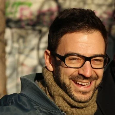 Mann mit Brille und Schal, lachend im Freien