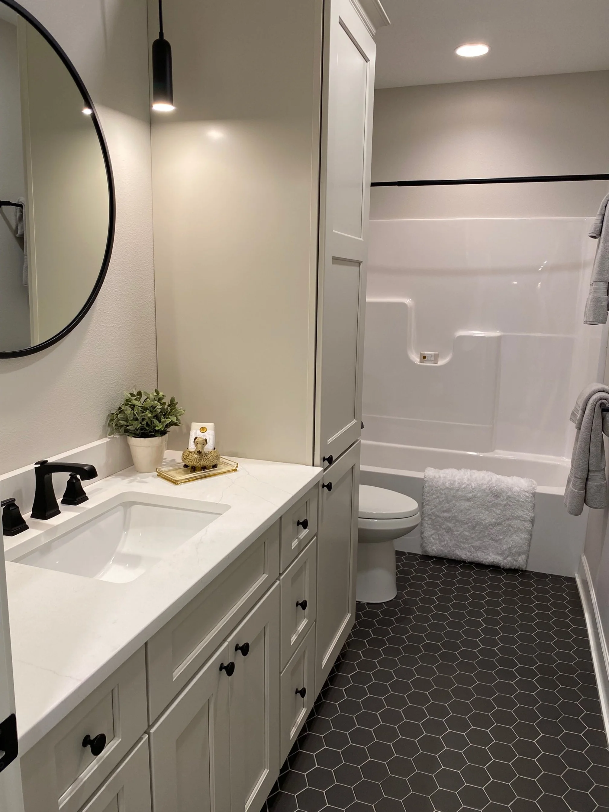 Modern upgraded bathroom with white vanity and black fixtures.