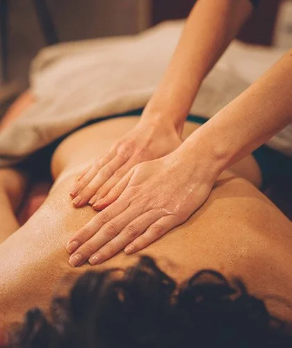 Massage du dos avec mains appliquant de l'huile