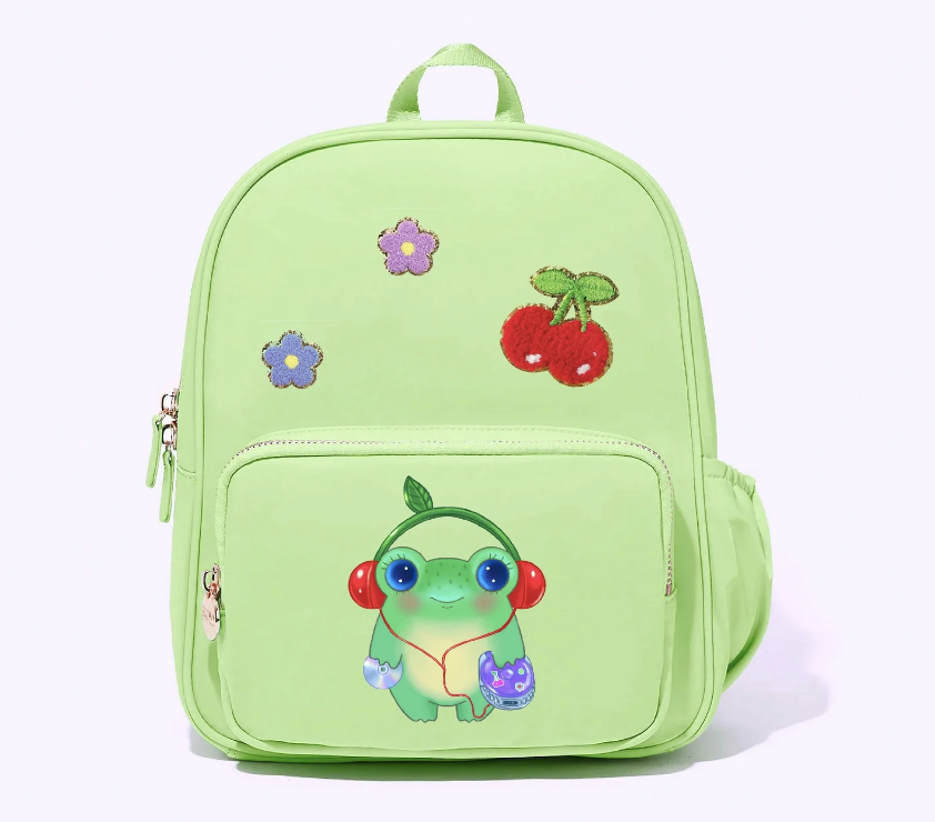 pastel green backpack of a frog wearing cherry headphones