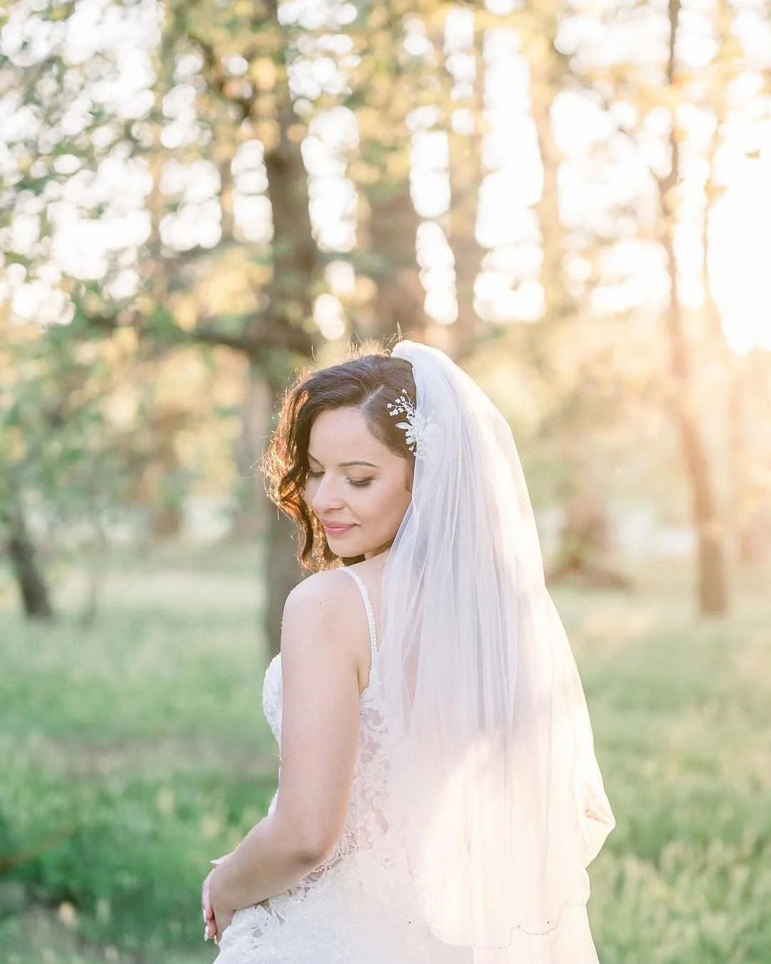 maquillage de mariage
Une mariée en robe blanche avec un voile, debout dans un parc lors d'un coucher de soleil, avec des arbres en arrière-plan.