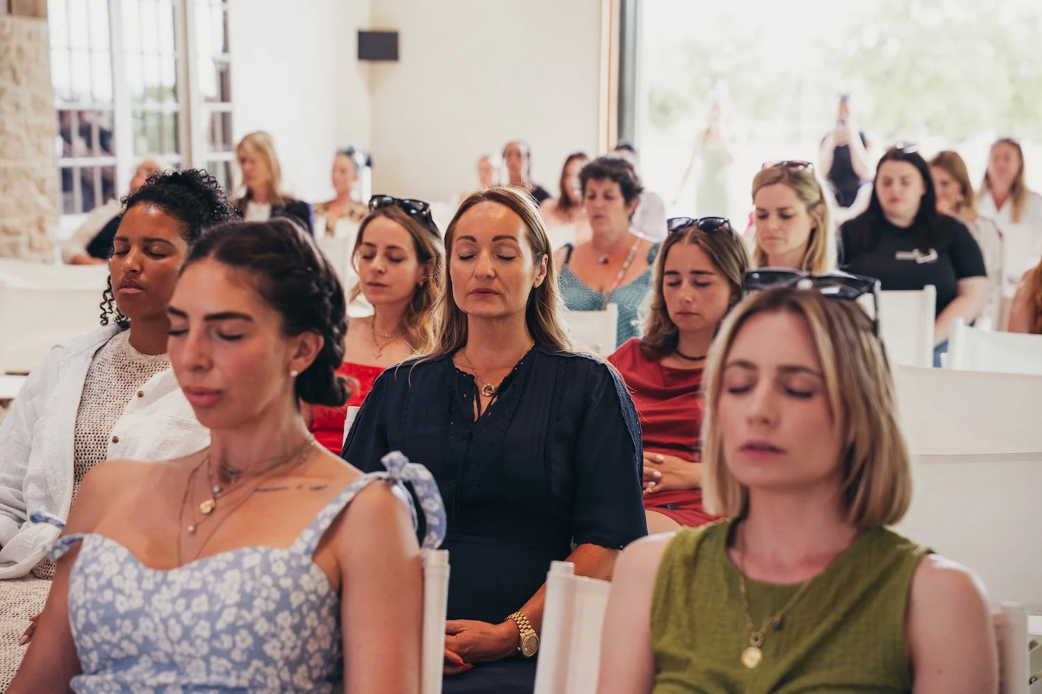 People sitting at a She's Electric event doing breathwork