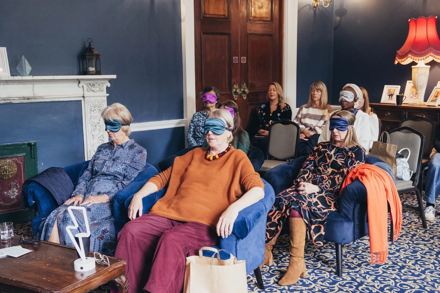 A group of women participating in breathwork  at a She's Electric event