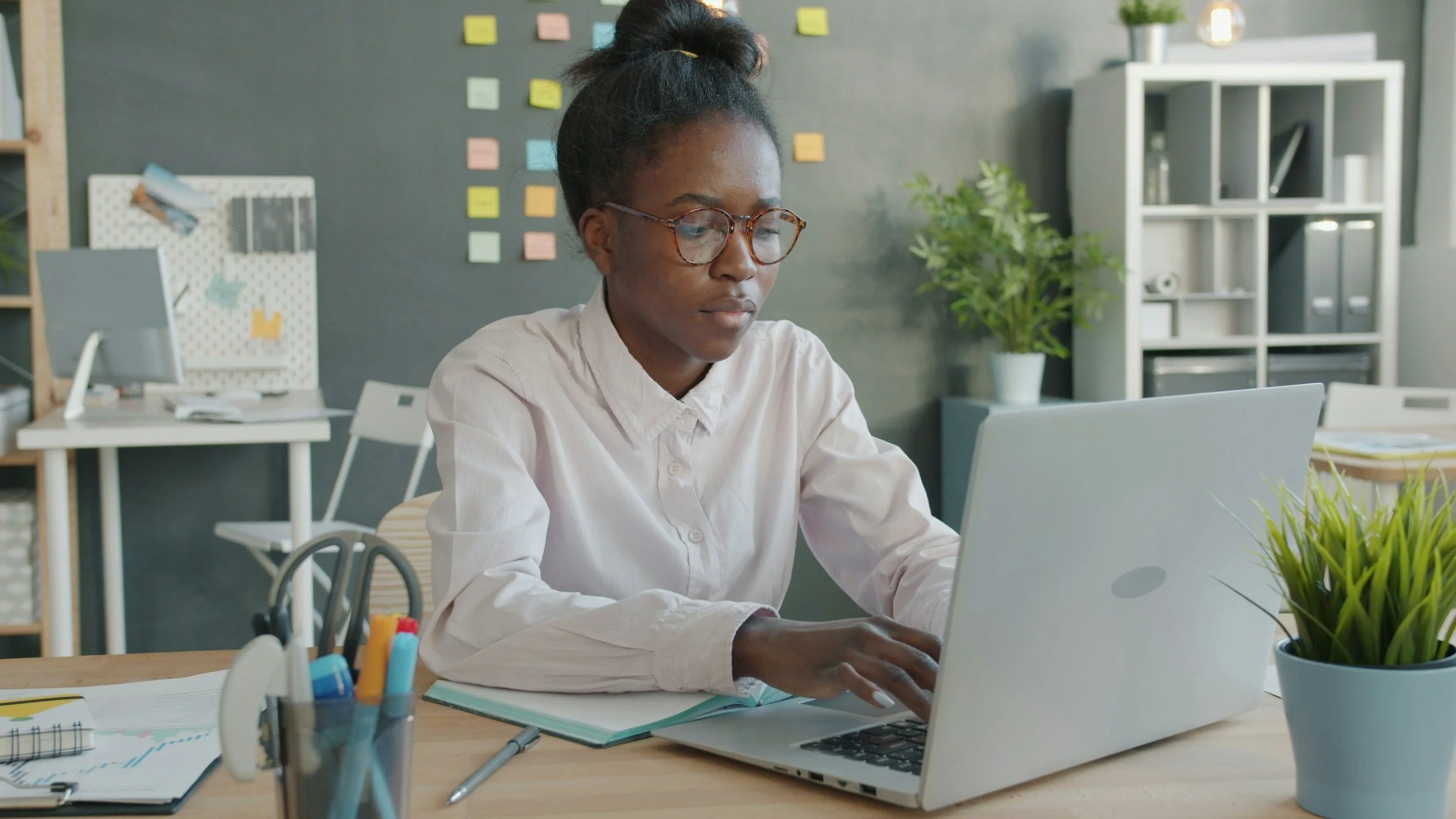 A stressed woman with glasses sits at her computer, reflecting the mental strain and overthinking that link OCD and perfectionism in daily life.