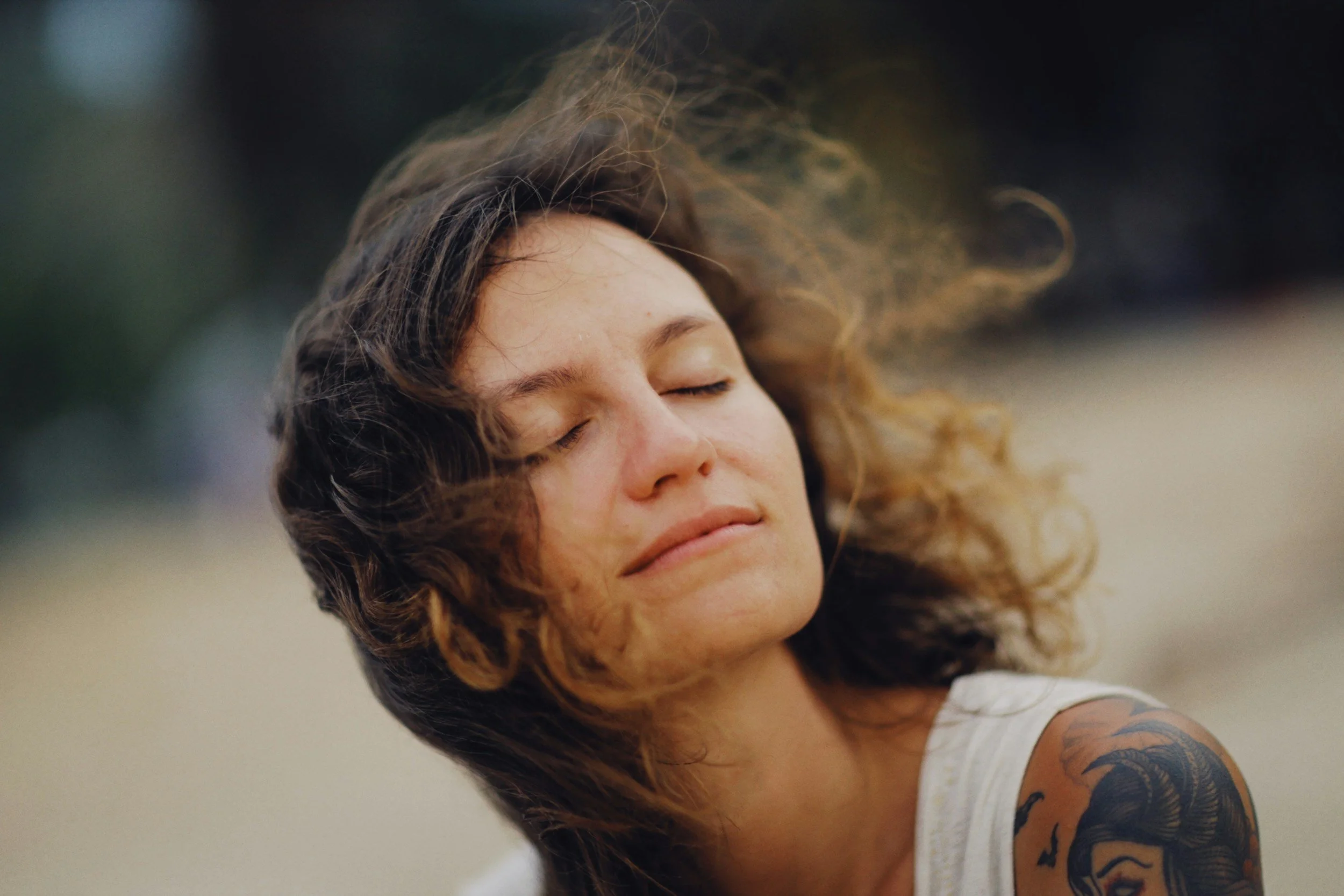 Woman with closed eyes and wind in her hair, symbolizing the calm that comes when understanding OCD becomes the explanation for long-standing fear.