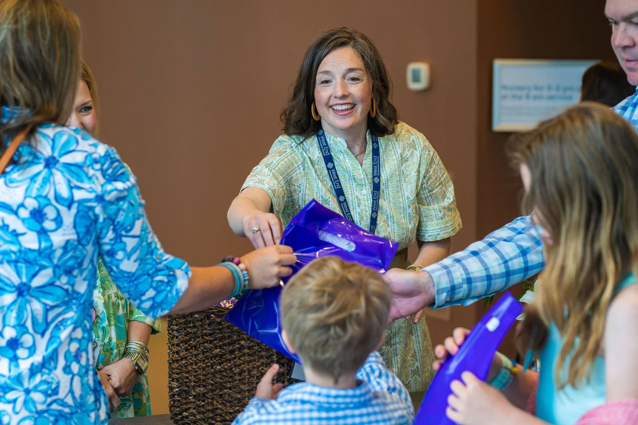 Laura Stacy passes out West End Kids worship kits to kids and families on Sunday at West End Community Church in Nashville, TN