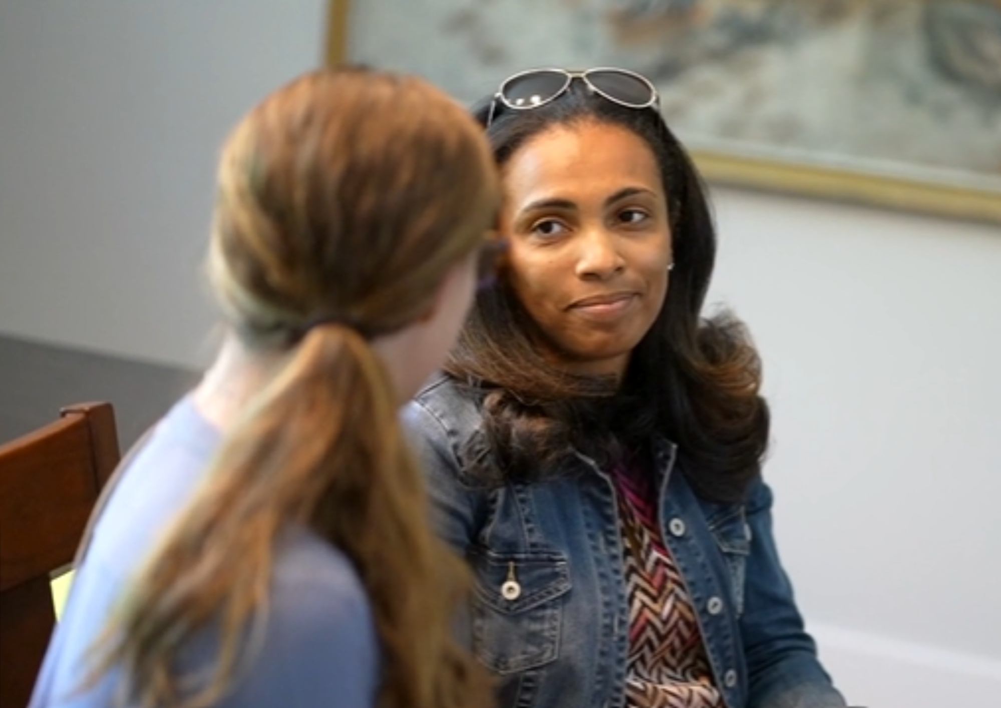 Two women sitting on a sofa at a Moms Thrive event having a conversation and enjoying friendship
