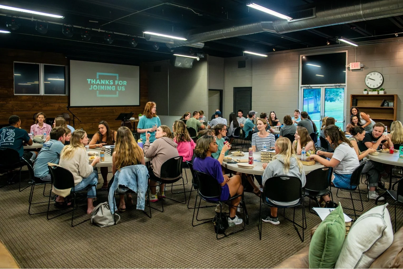 Room full of people at 6 tables during Tuesday night bible studies
