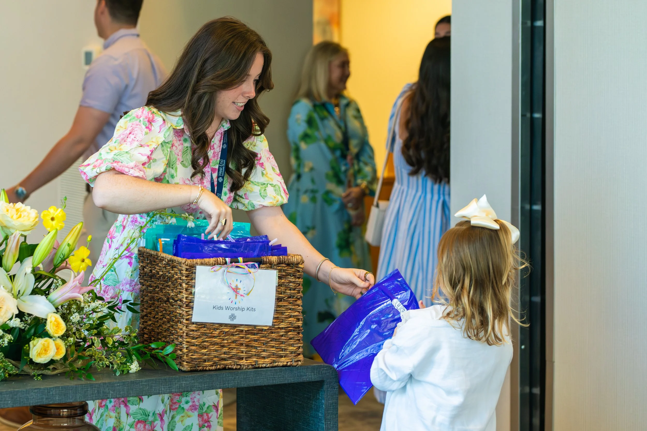 A church volunteer hands a child a children's activity bag before going to worship service at West End Community Church in Nashville, TN